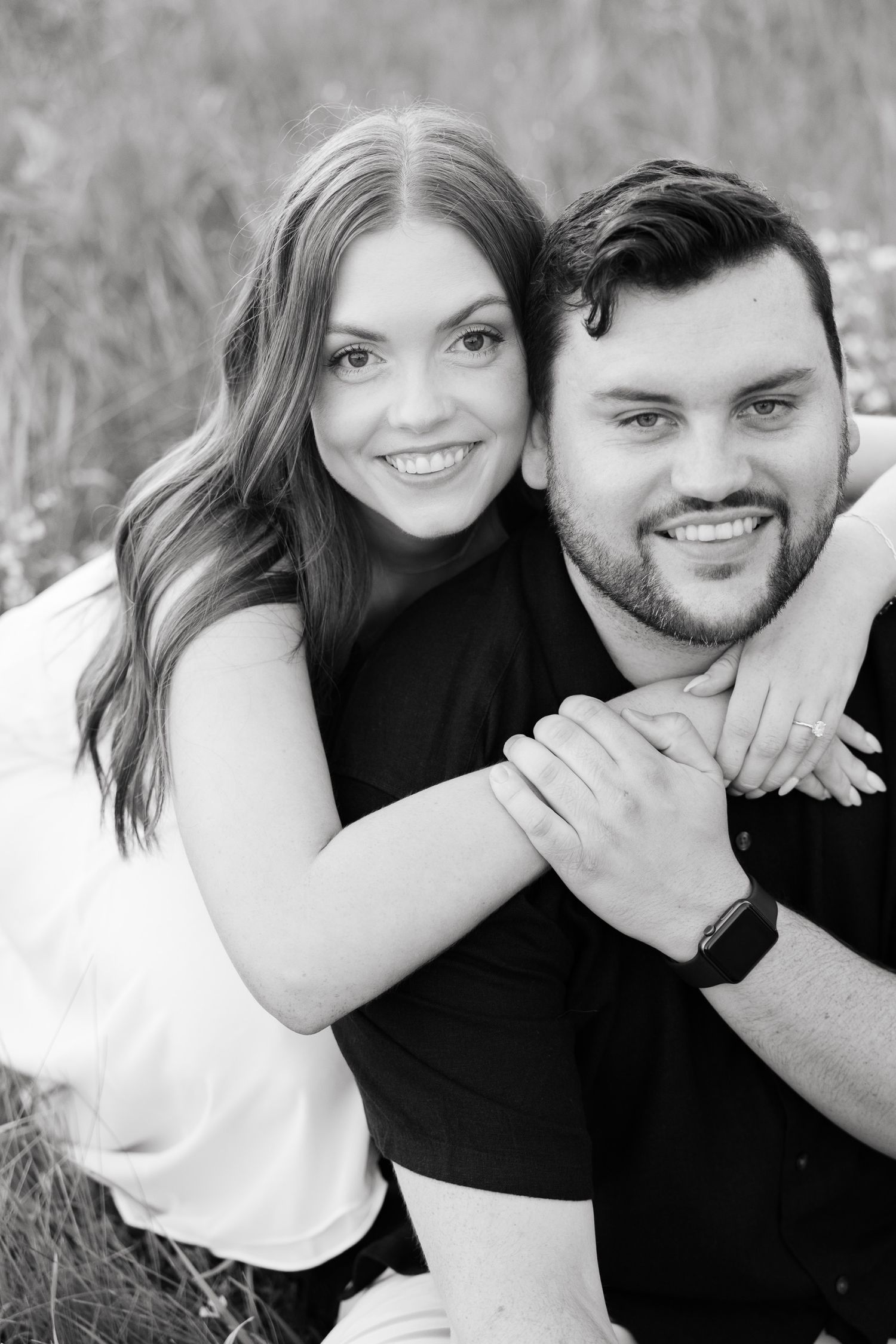 Black and white portrait of couple sharing affectionate moment outdoors.