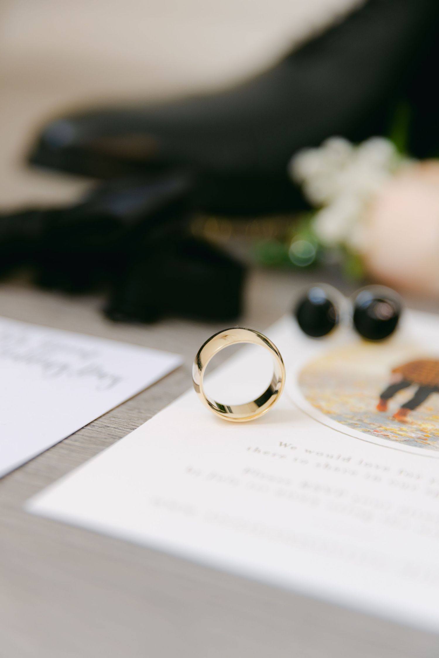 A wedding ring and invitation details captured in elegant macro photography.