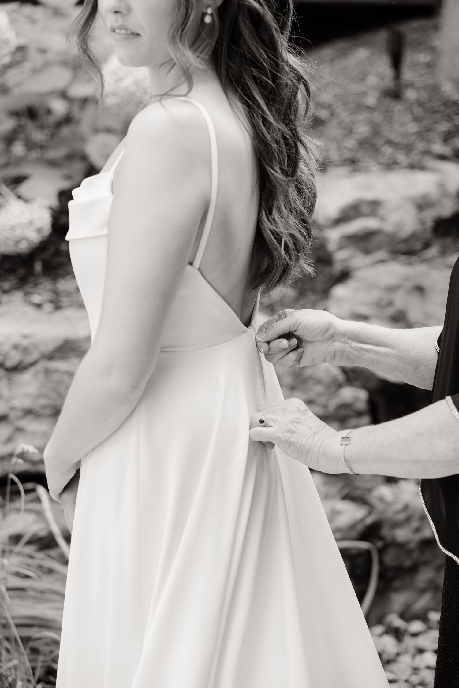 Close-up black and white shot of dress adjustments being made.