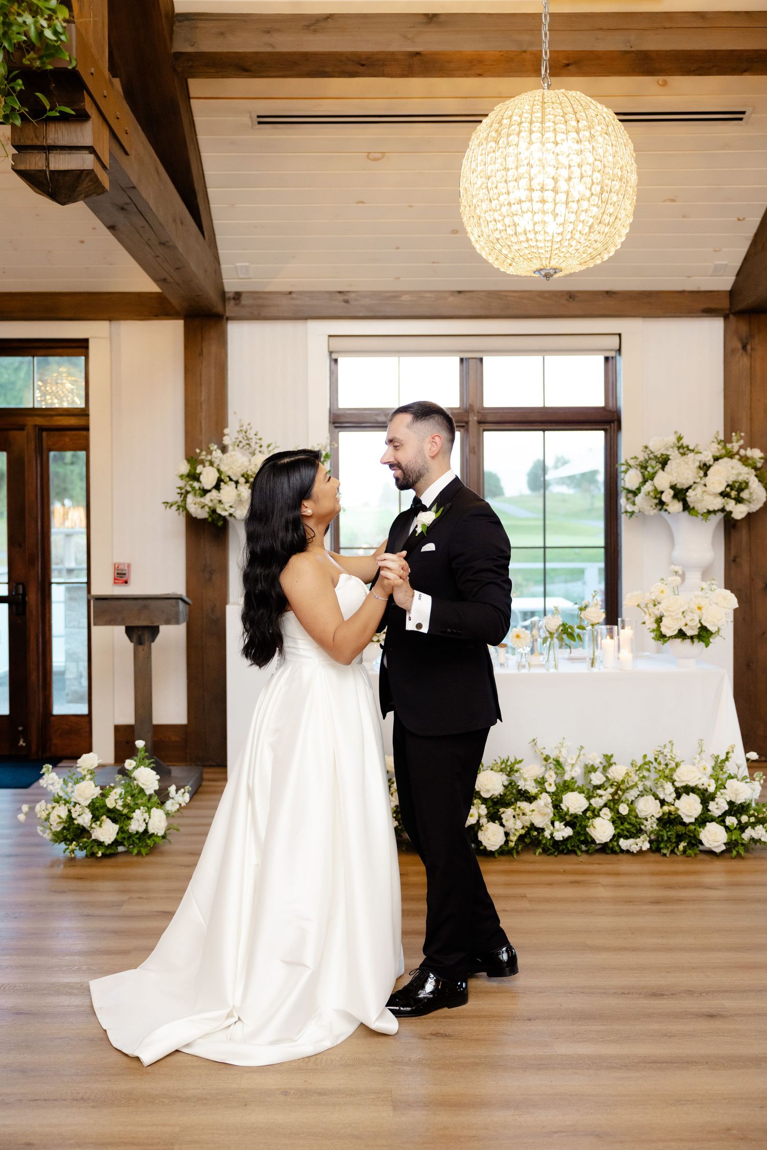 A romantic moment captured during a wedding dance beneath a glowing spherical light fixture.