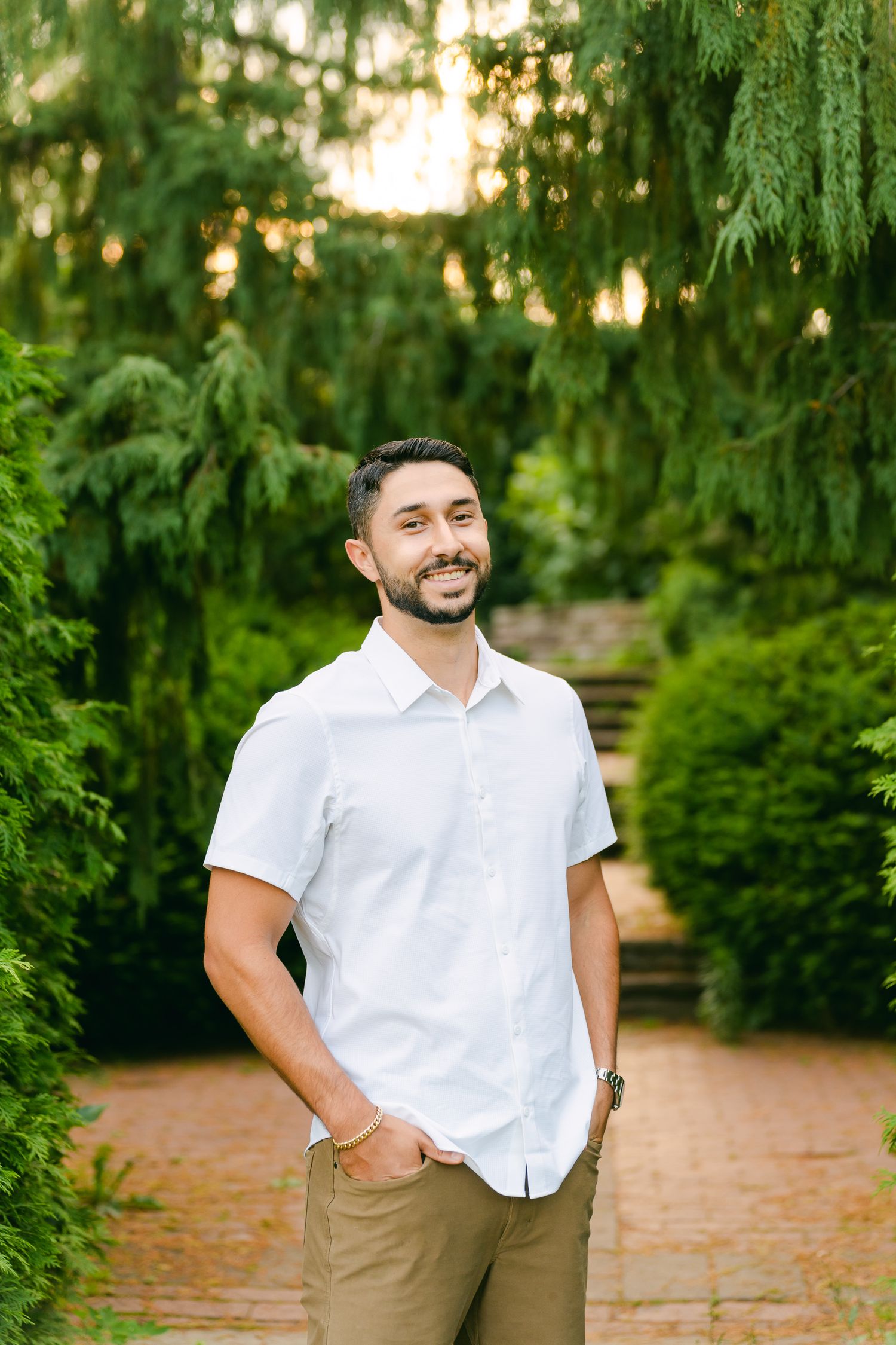 A casual summer portrait on a brick pathway surrounded by hanging willow branches.