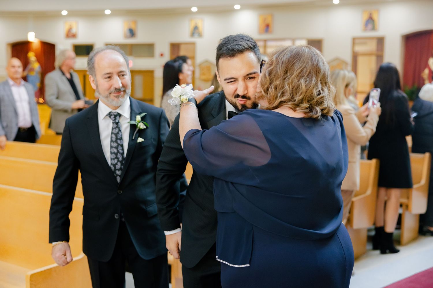 Emotional moment during wedding ceremony as guests gather in church hall.