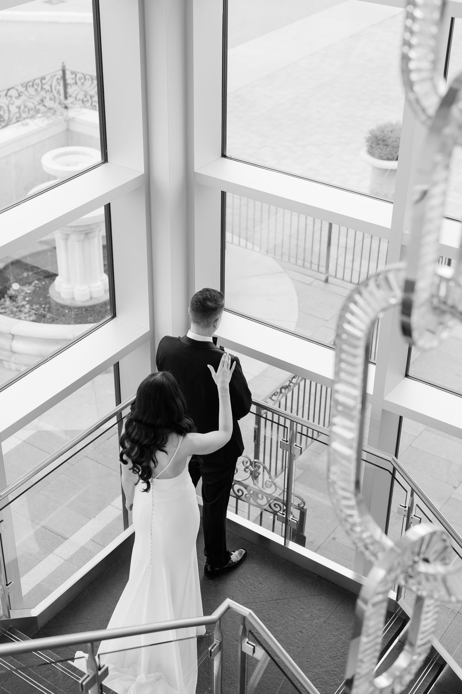 A black and white photo captures an intimate first look moment between newlyweds.