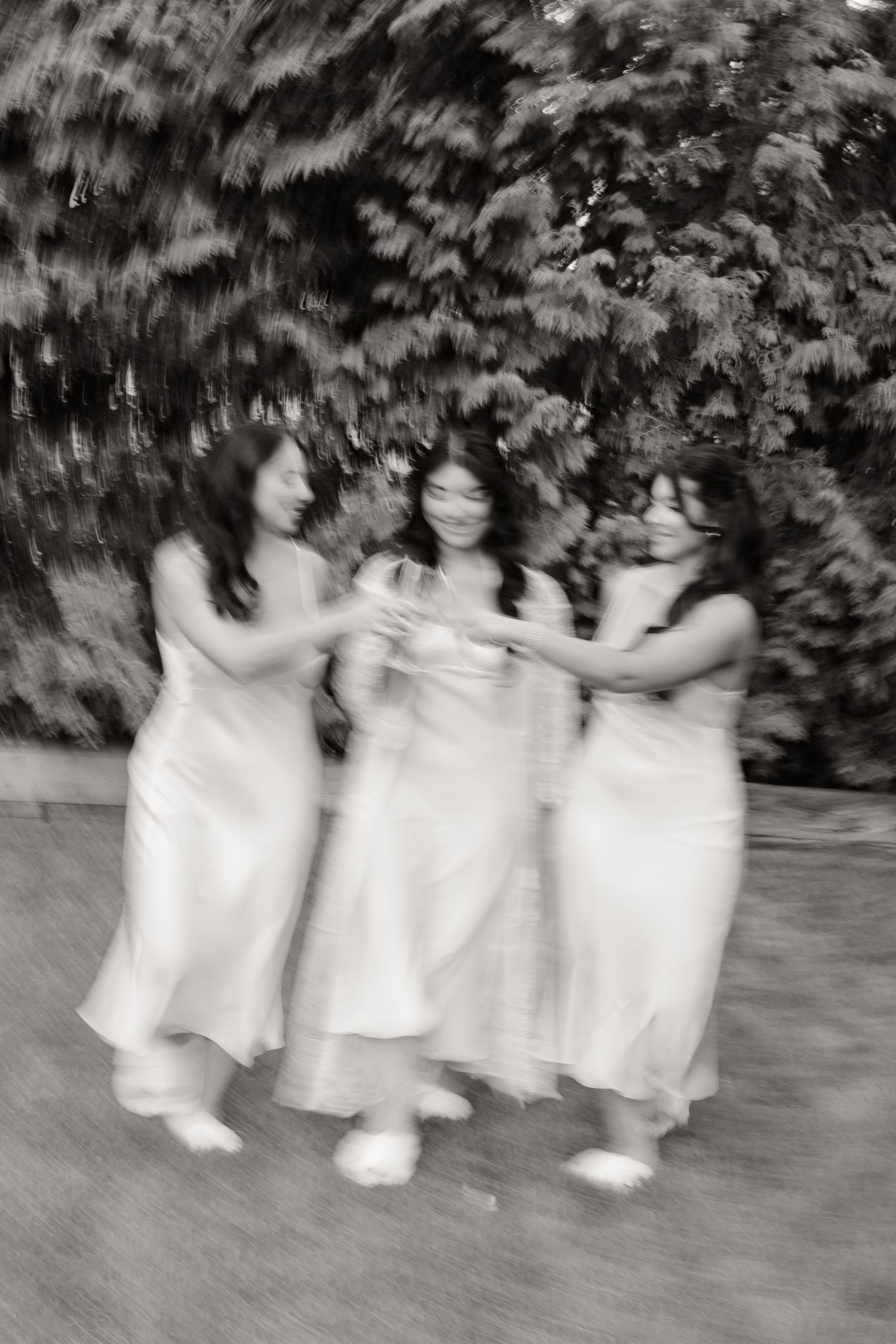A time-lapse sequence shows three small figures in white dresses moving across the frame against a dark garden backdrop.