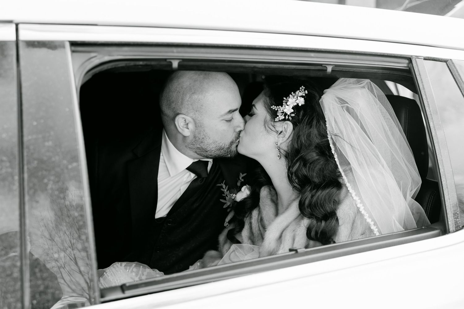 Black and white vintage wedding photo captured through car window.