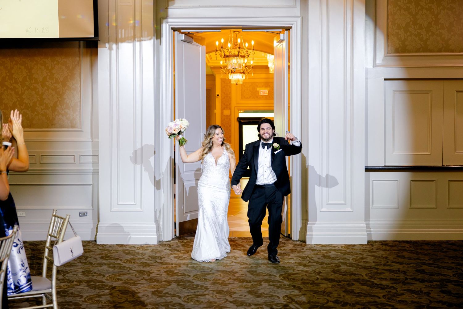 Wedding celebration exit through grand ballroom doors.