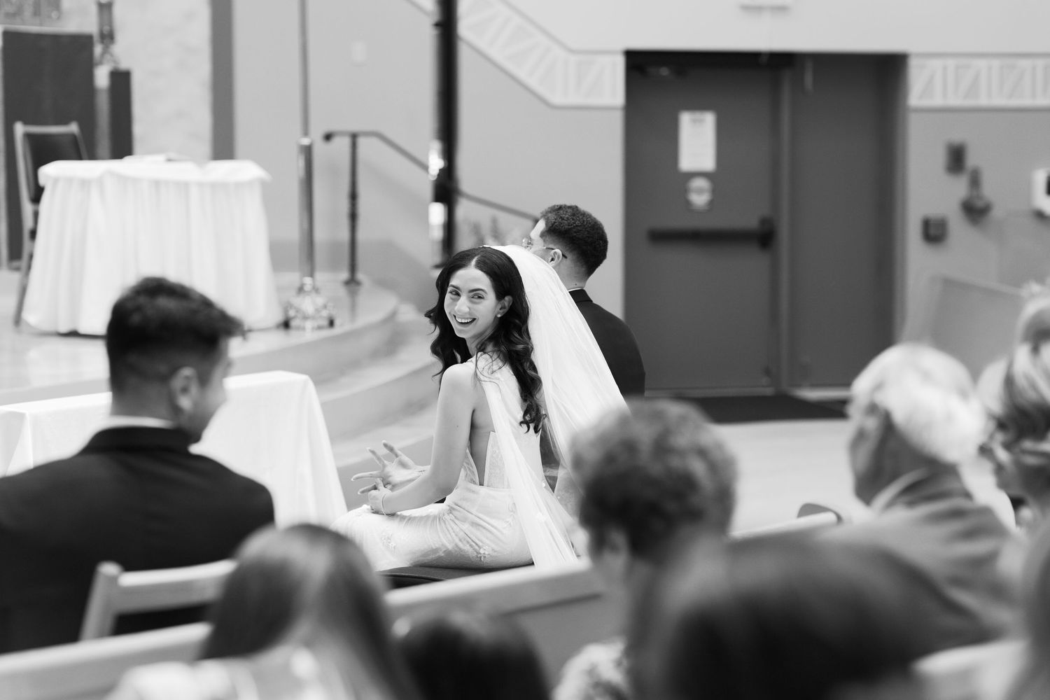 A black and white photo capturing a joyful wedding ceremony moment.