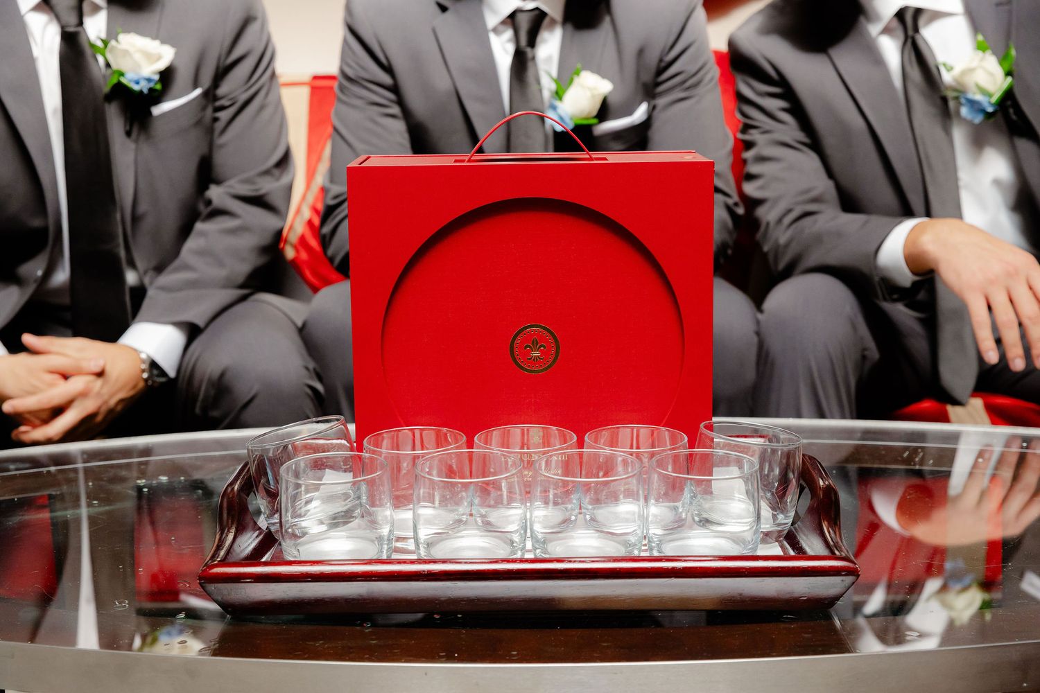 Formal event setup with crystal glasses on red tablecloth.