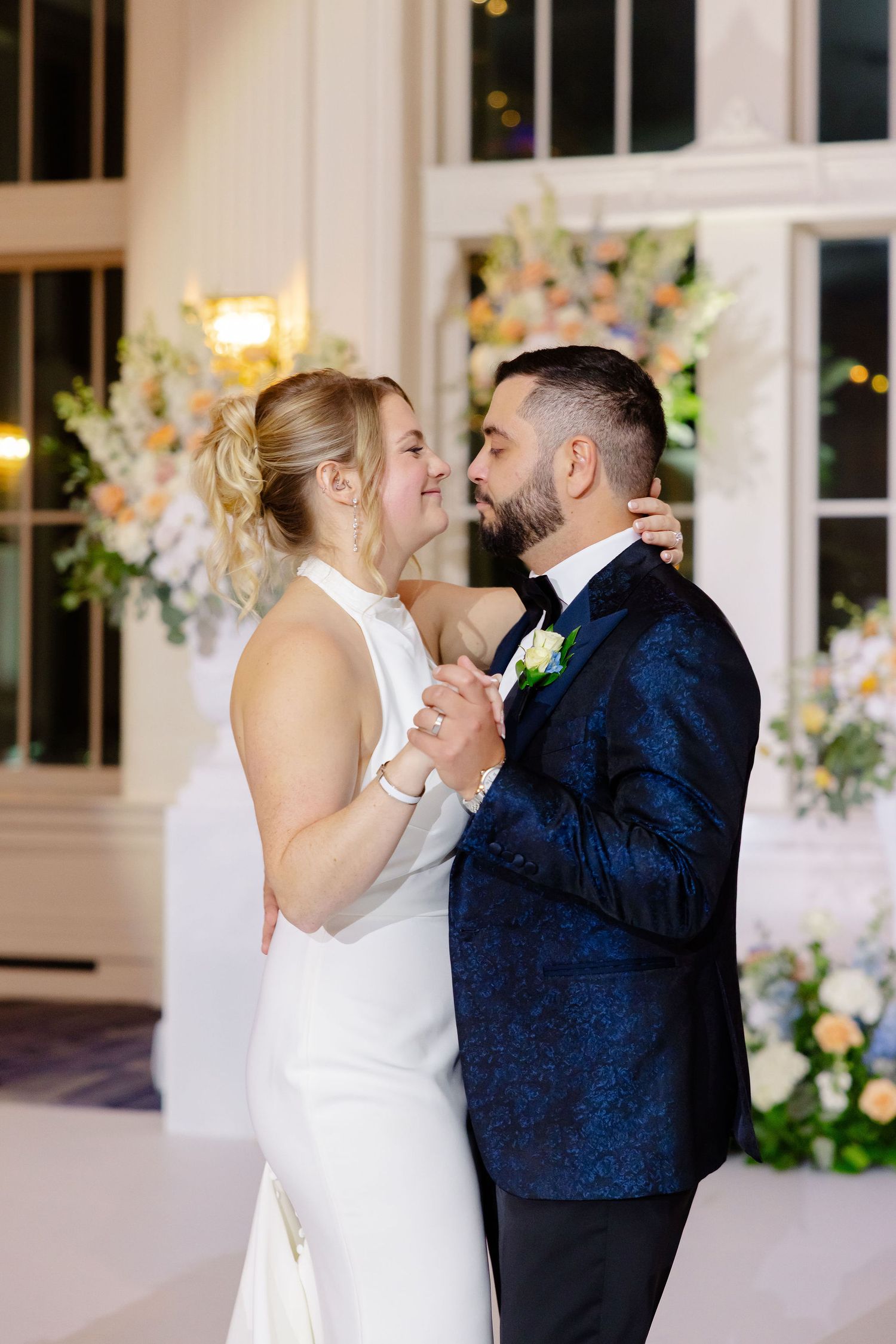 Couple shares romantic dance moment in an elegantly decorated wedding reception hall.