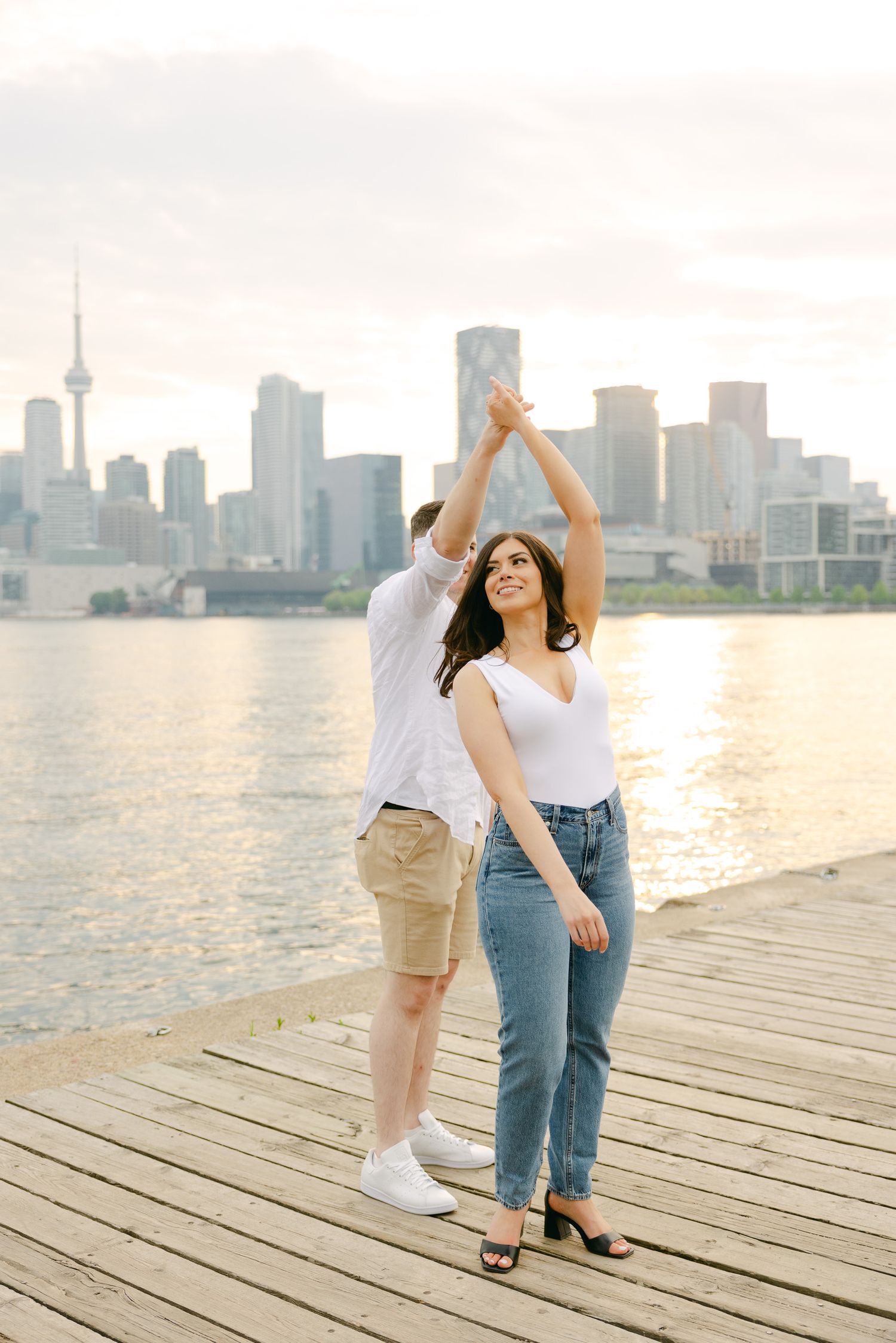 Dancing couple on waterfront deck with Toronto's distinctive skyline behind them.