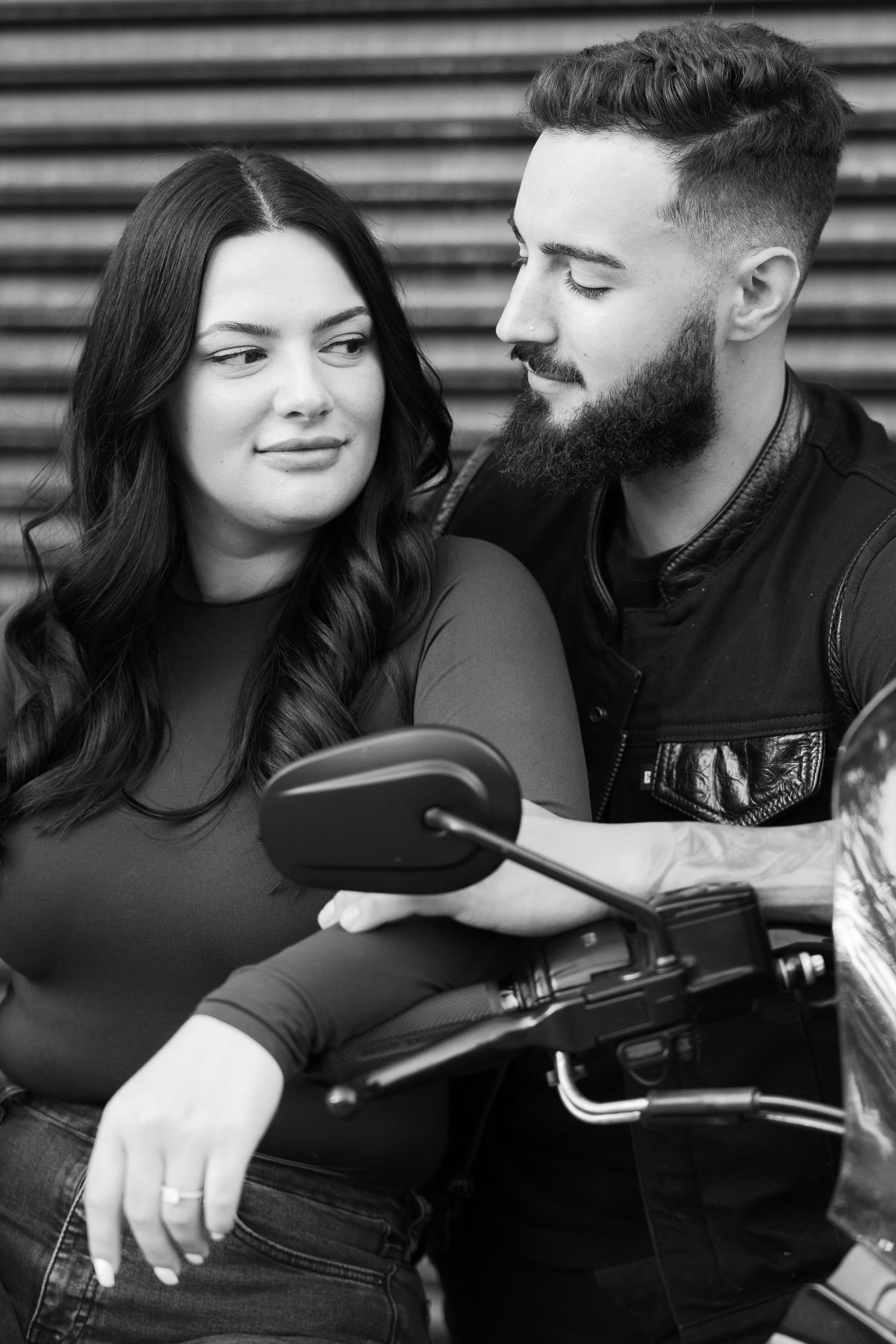 Black and white portrait of a couple with their motorcycle.