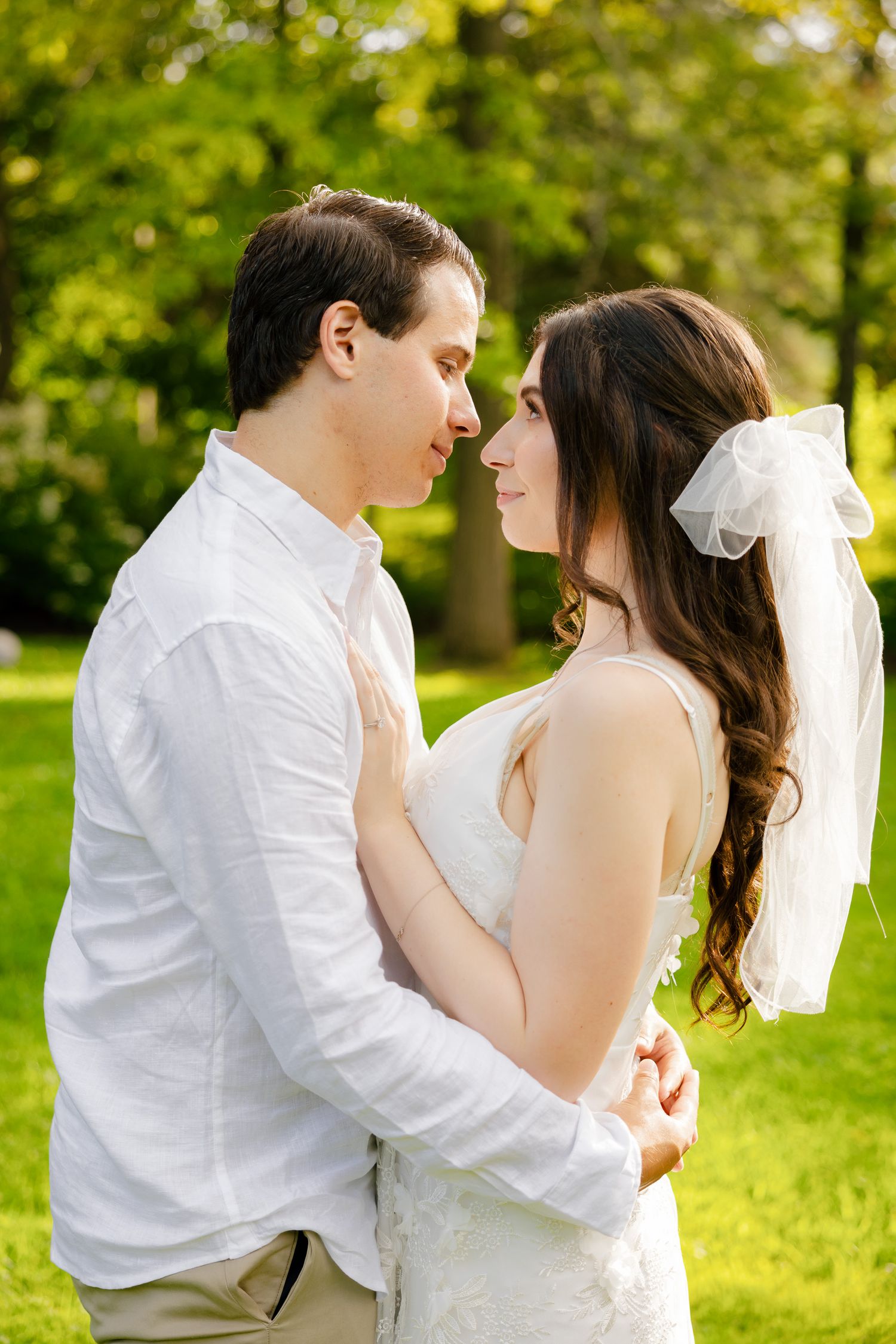 A tender moment between newlyweds in a sun-dappled garden setting.