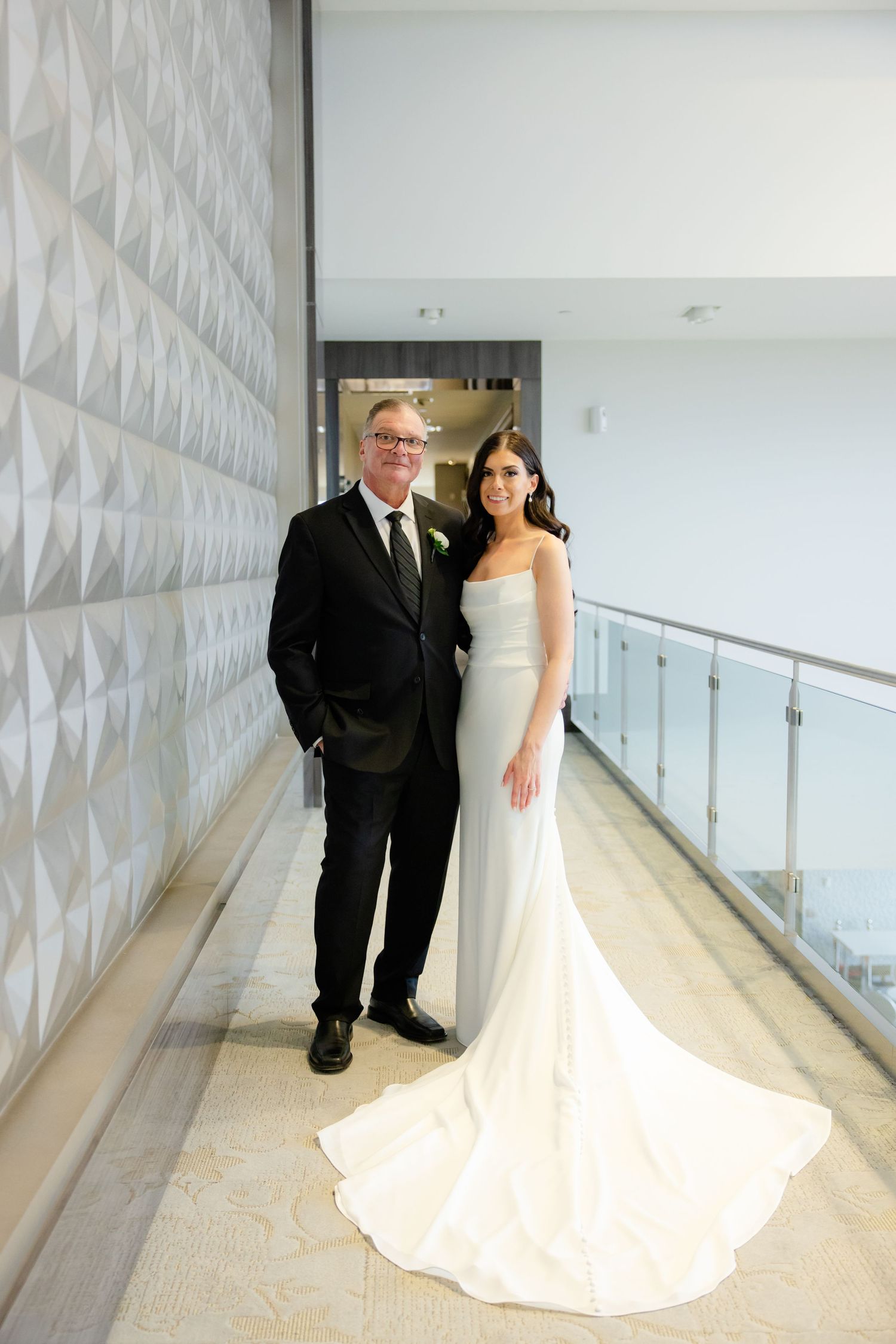 Elegant hallway portrait with textured wall features bride in flowing white gown.