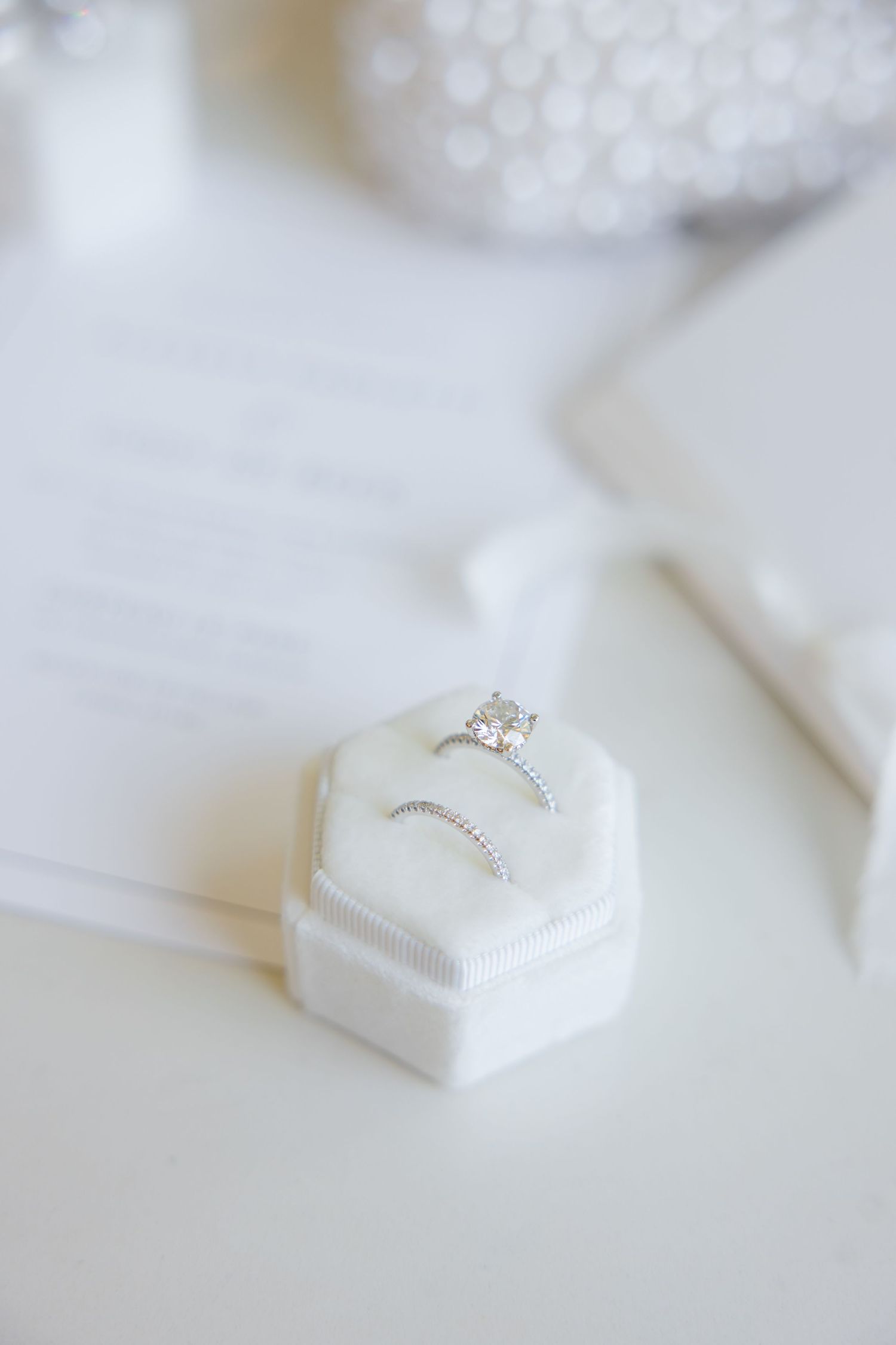 Diamond engagement ring and wedding band in white hexagonal box.
