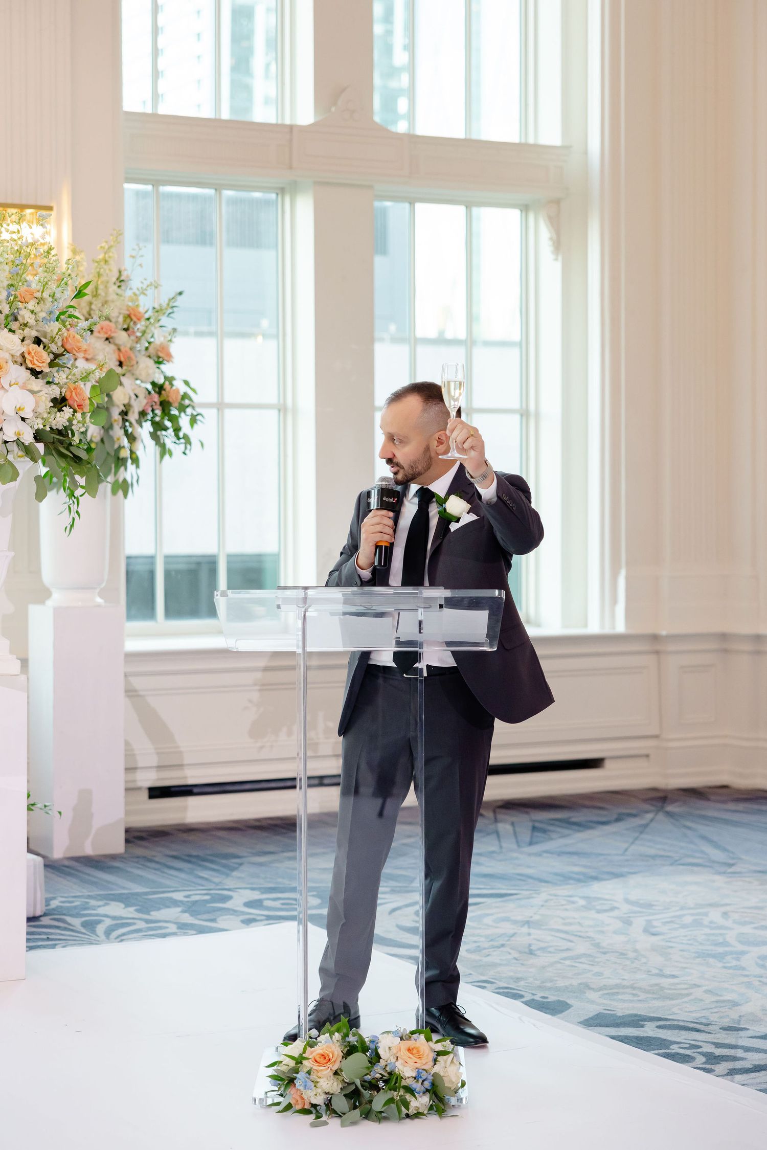 Elegant wedding venue with white columns and floral arrangements in a bright ballroom setting.