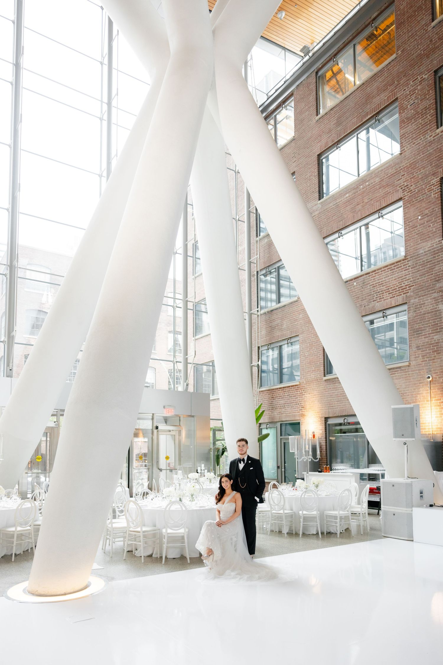 Wedding reception space with dramatic white architectural columns and elegant table settings.