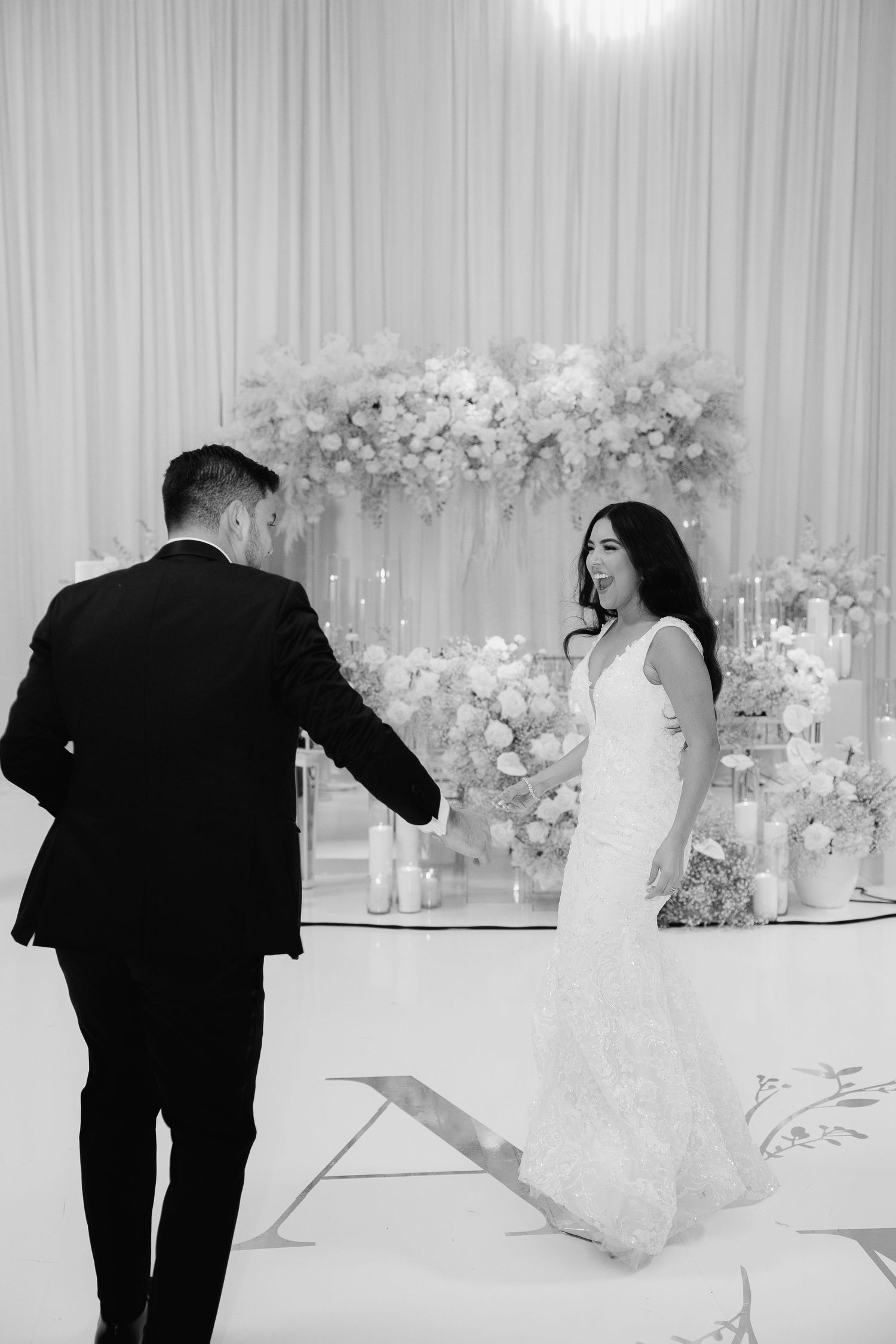 A romantic moment between newlyweds on their wedding day with floral decor in the background.
