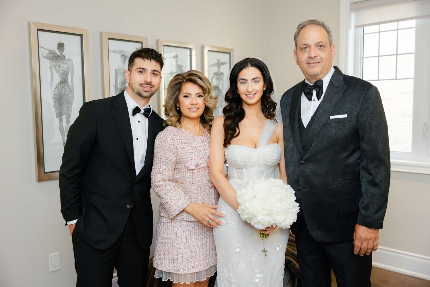 Formal indoor wedding portrait with family members in elegant attire.
