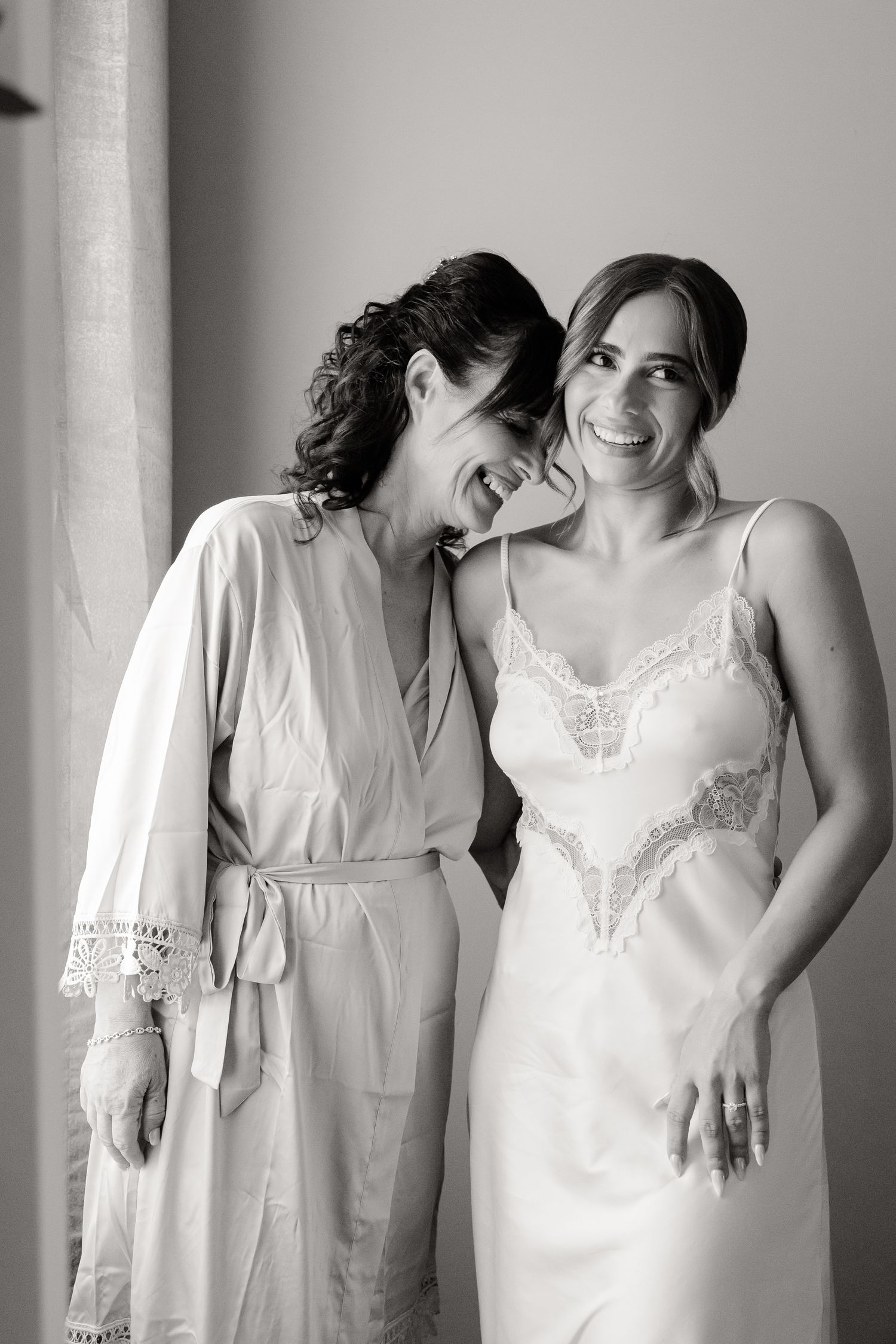 A series of black and white photos showing two people in white dresses sharing tender moments.