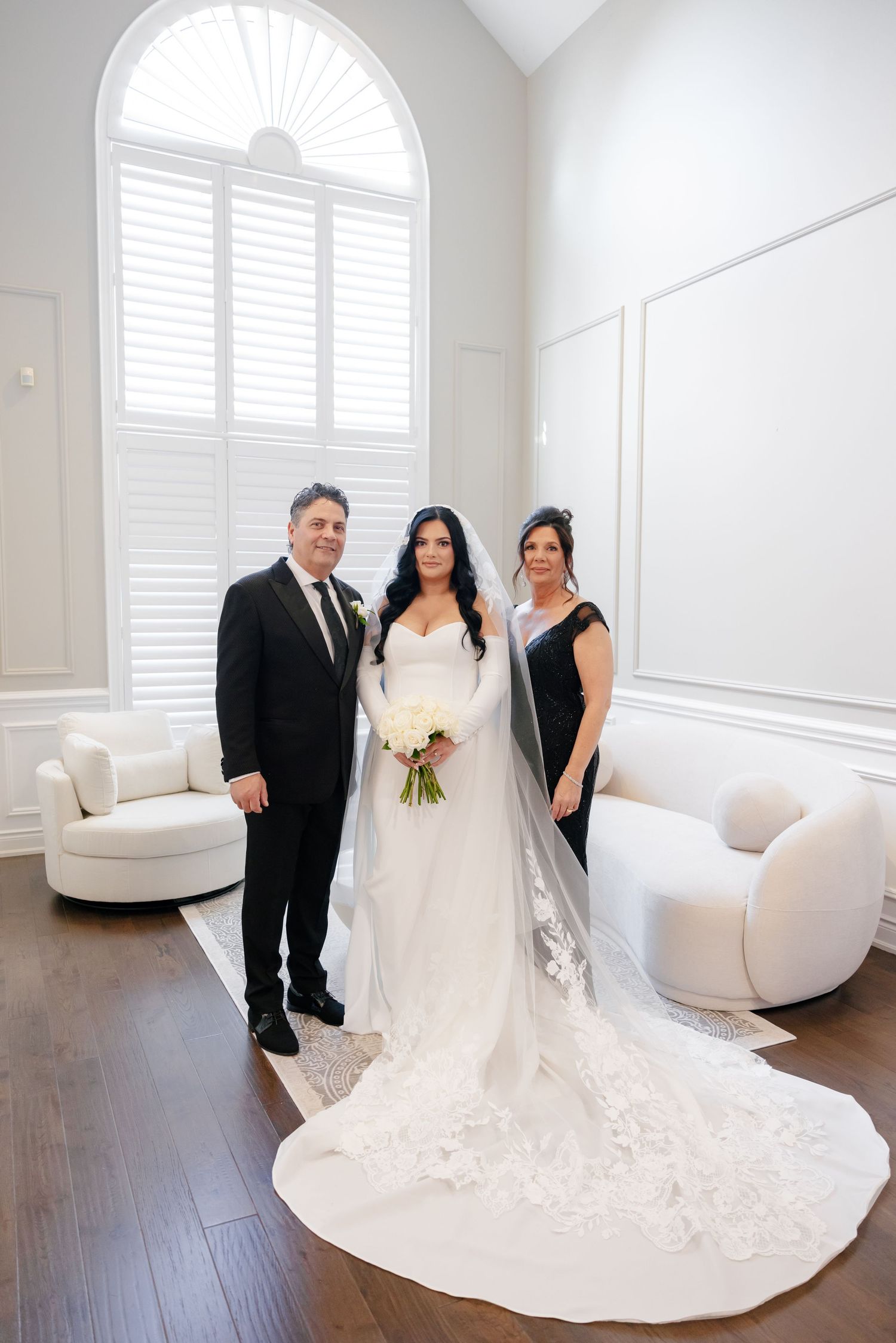 Wedding portrait in bright modern room with dramatic cathedral train.