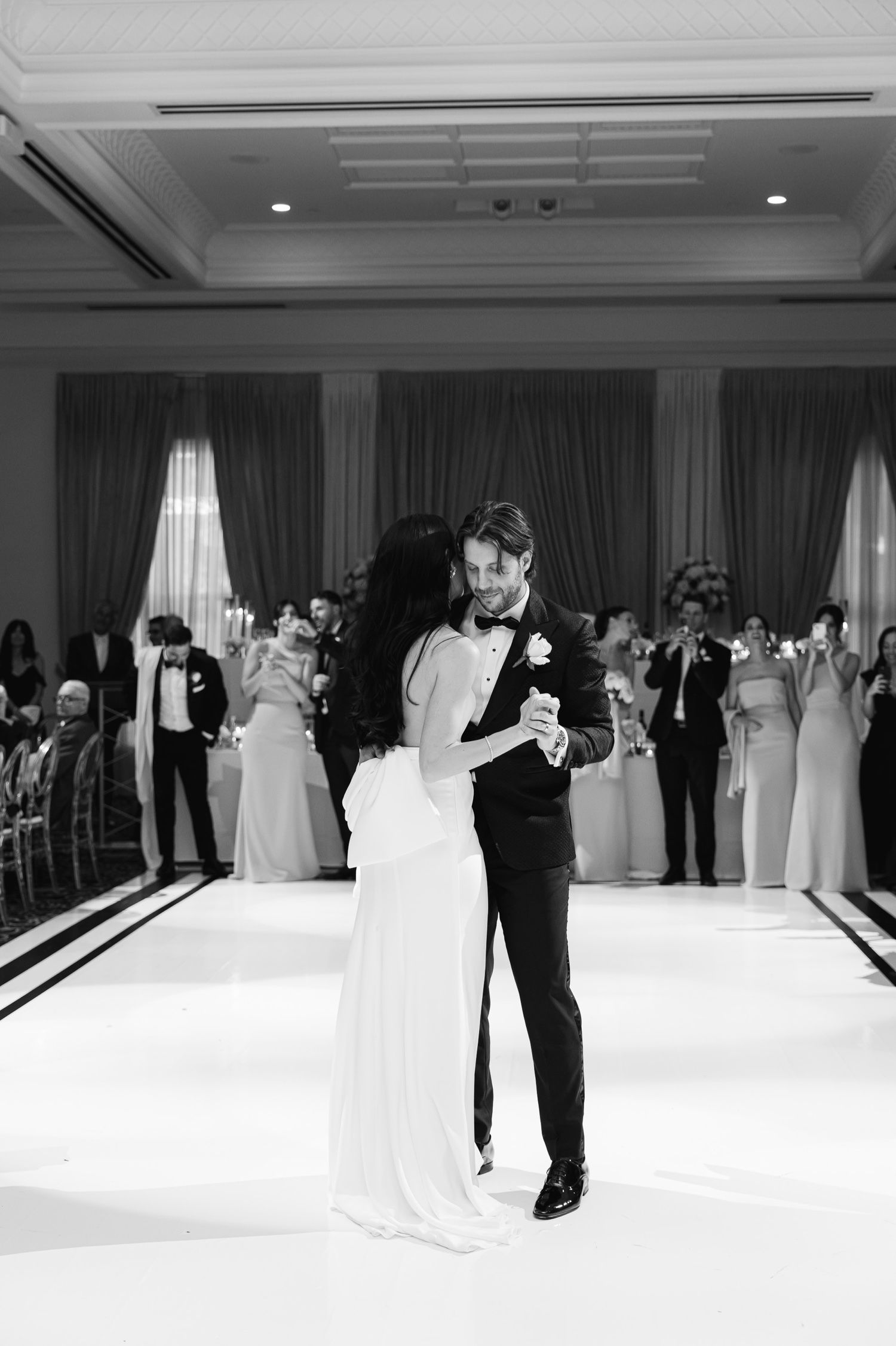 Black and white capture of romantic first dance at elegant wedding reception.