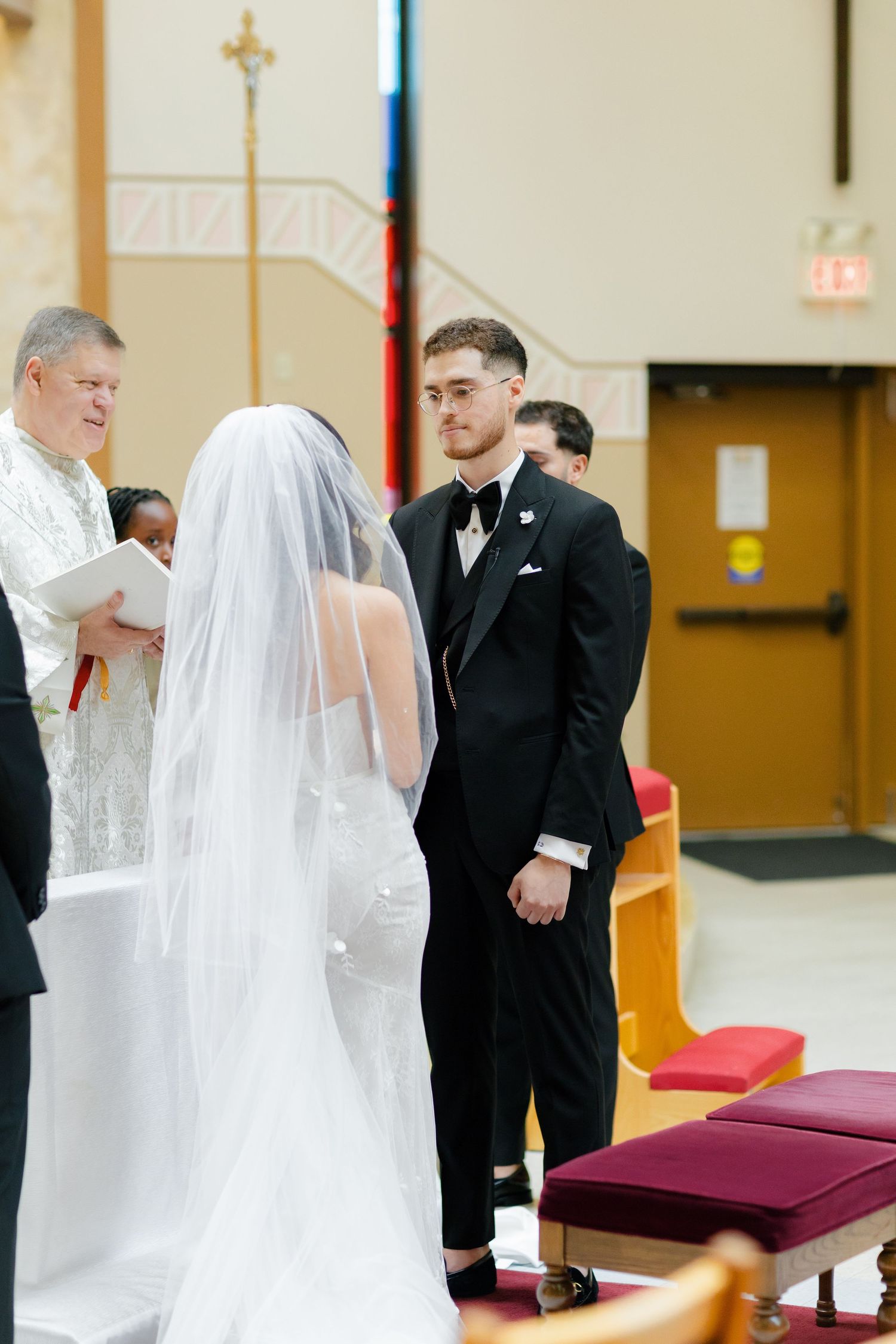 Wedding ceremony in progress at the altar with priest presiding over the service.