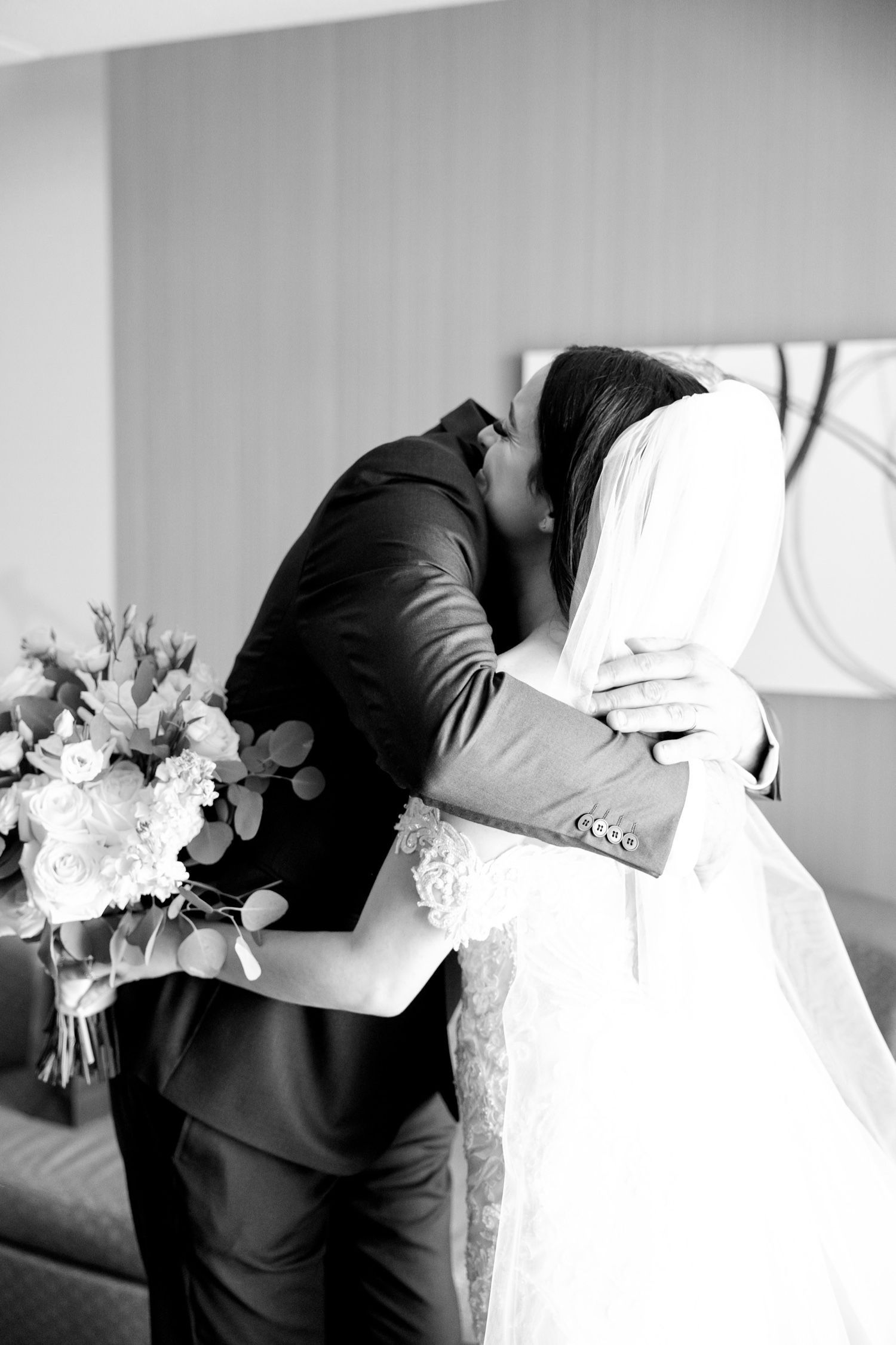 Black and white emotional moment between wedding couple sharing an embrace.