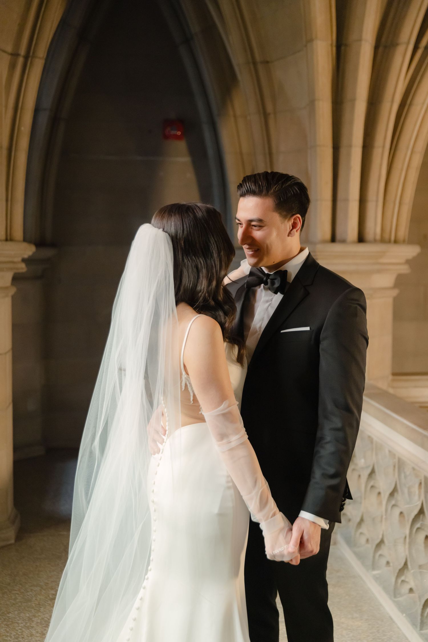 An intimate wedding portrait in a cathedral hallway with beautiful architectural details.