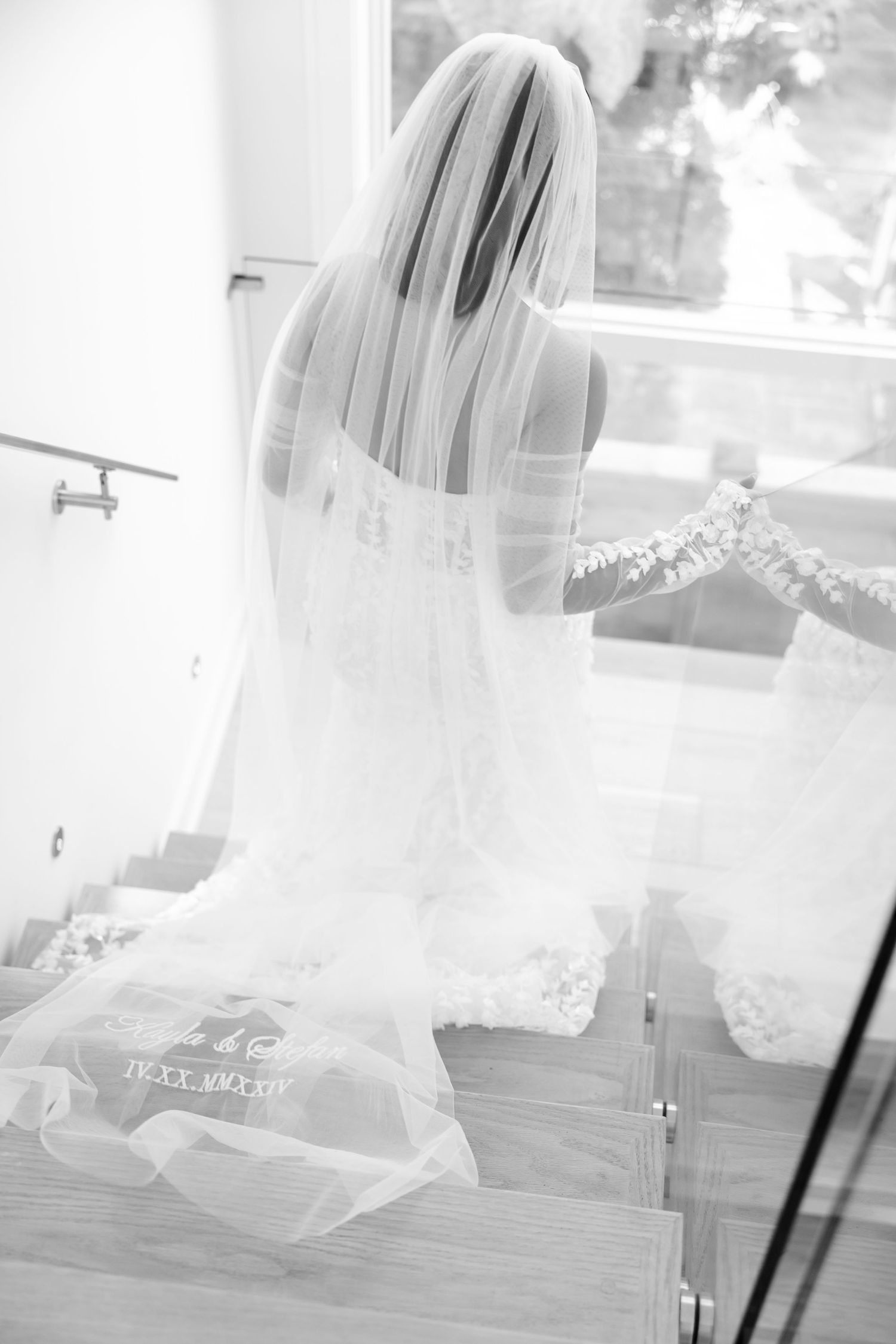 A flowing bridal veil cascades down a staircase in black and white photography.
