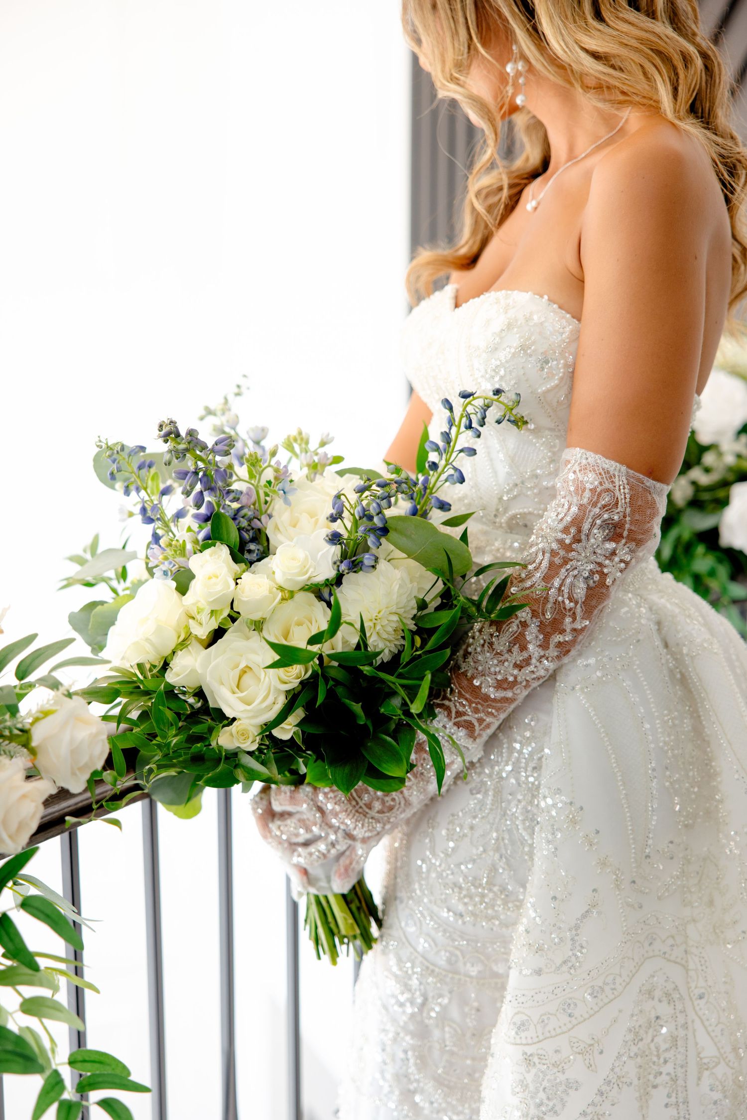 Classic white wedding dress with delicate lace sleeves and a stunning bouquet of white roses.