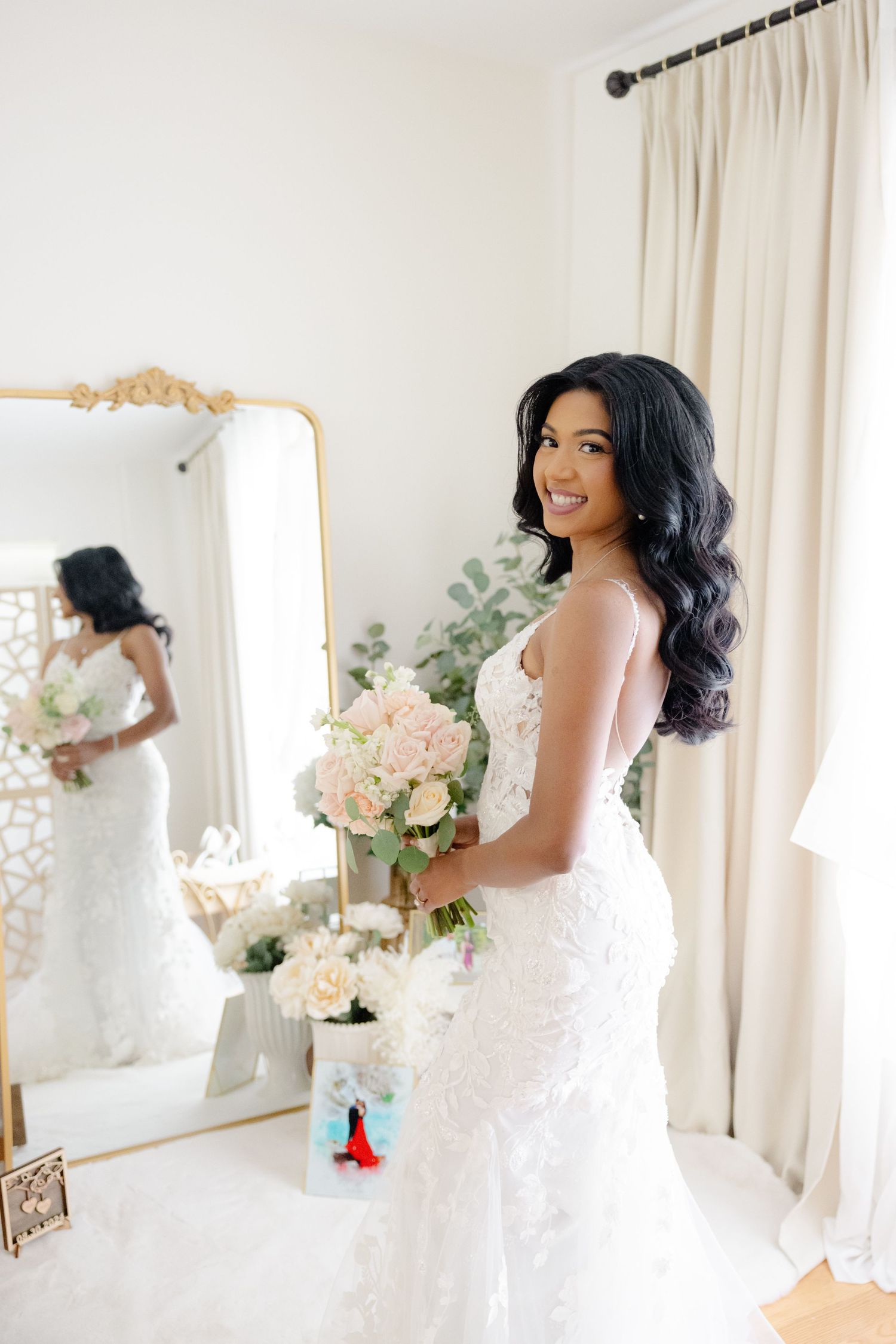 Beautiful wedding dress detail with flowing white lace and delicate floral patterns in a bright elegant setting.