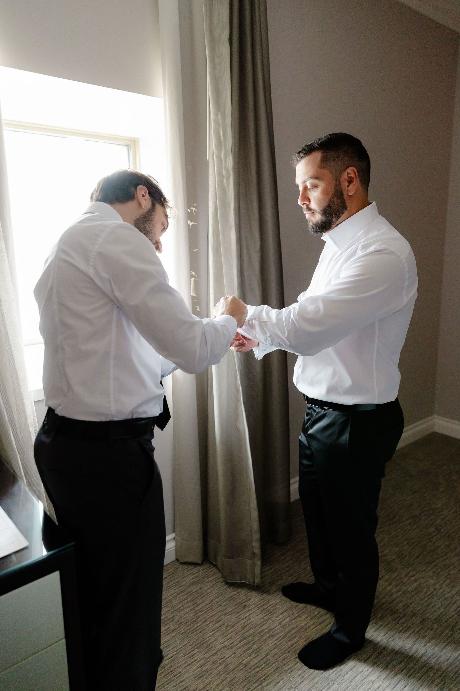 A sequence of images shows two people in formal attire adjusting curtains in a hotel room.