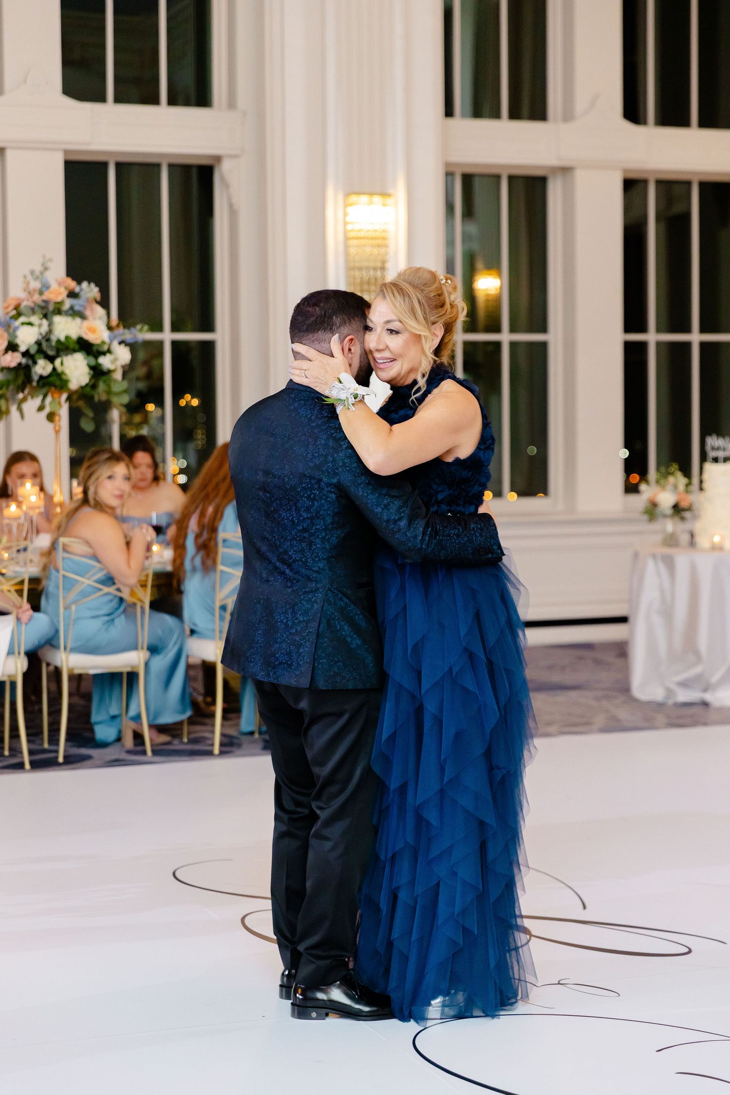 Couples dancing in navy blue formal wear during an elegant wedding reception.