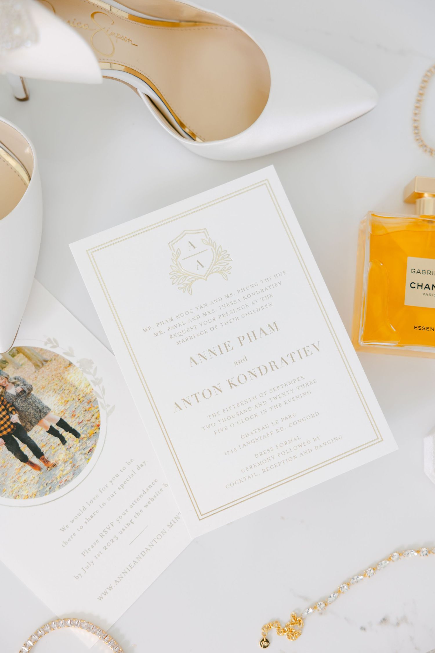 Elegant white and gold wedding invitation with Chanel perfume and accessories.