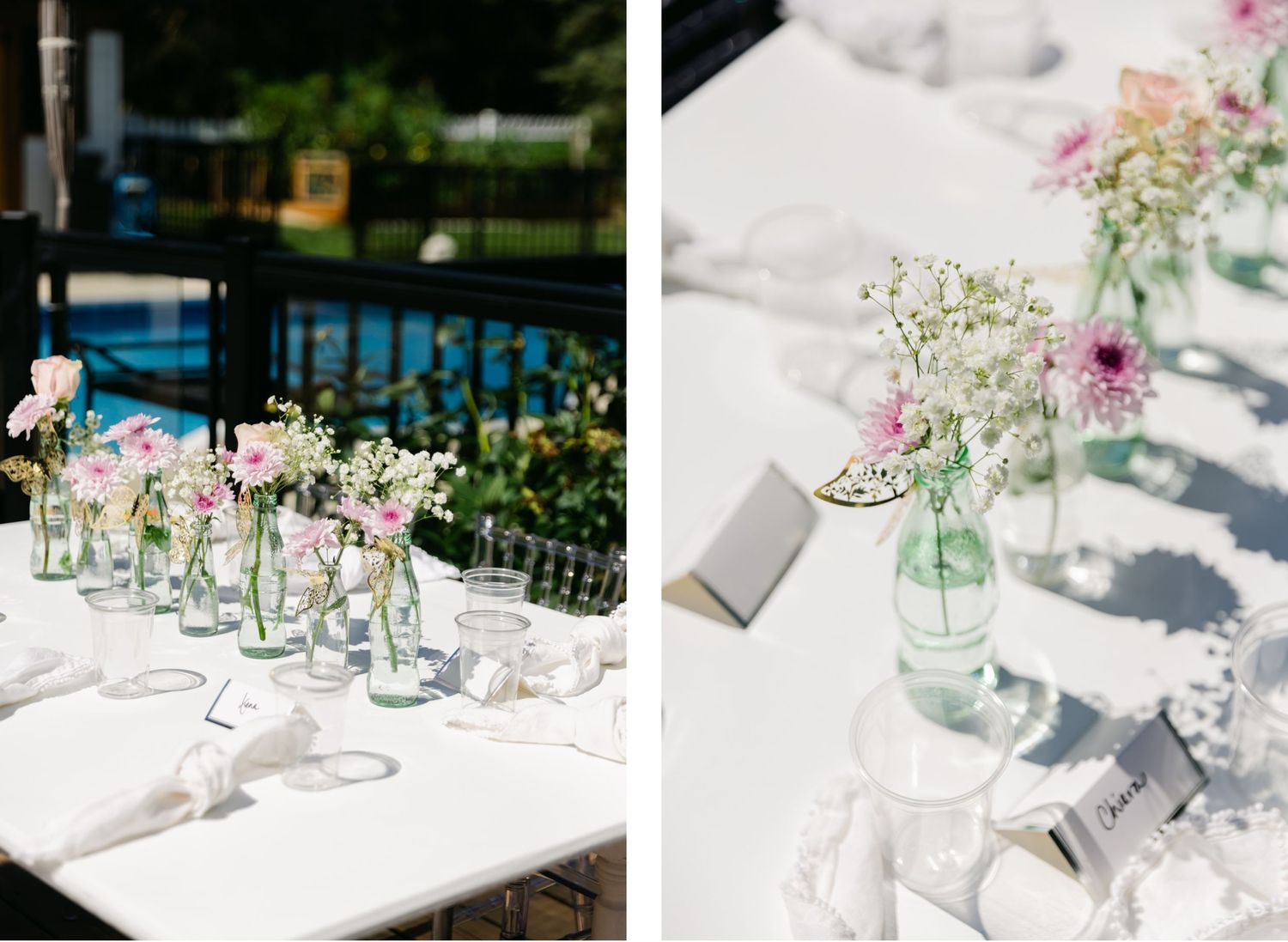 Glass bottle flower arrangements with pink blooms line white reception tables near a pool.