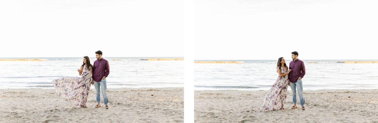 A couple stands together on a beach at sunset with water and sky in the background.