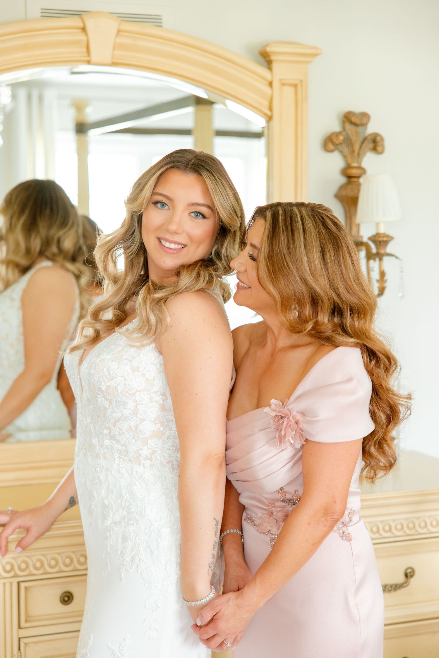 Elegant bridal scene with cream colored vintage vanity and mirror reflections.