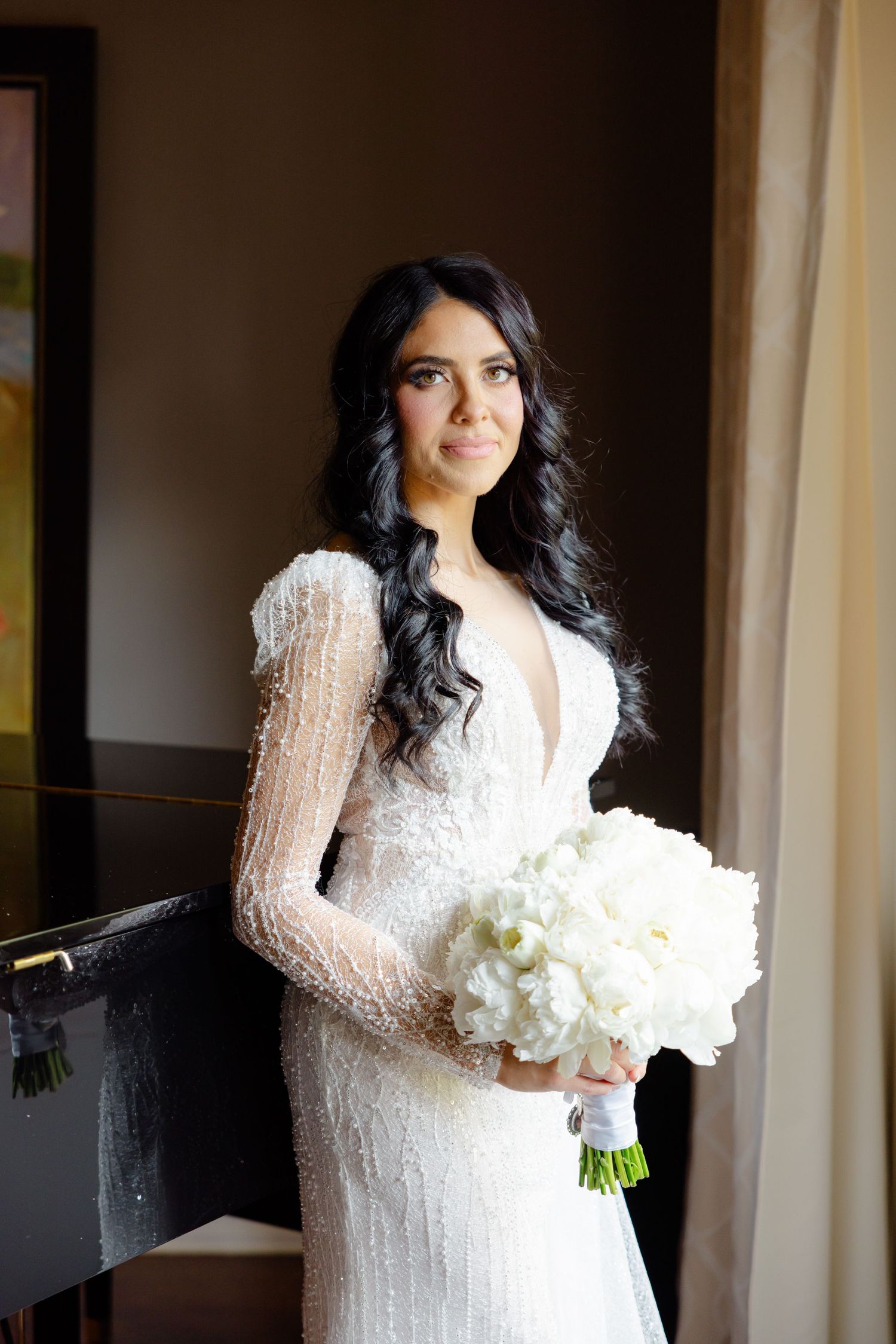 Classic bridal photo showing intricate beaded wedding dress and white peony bouquet.