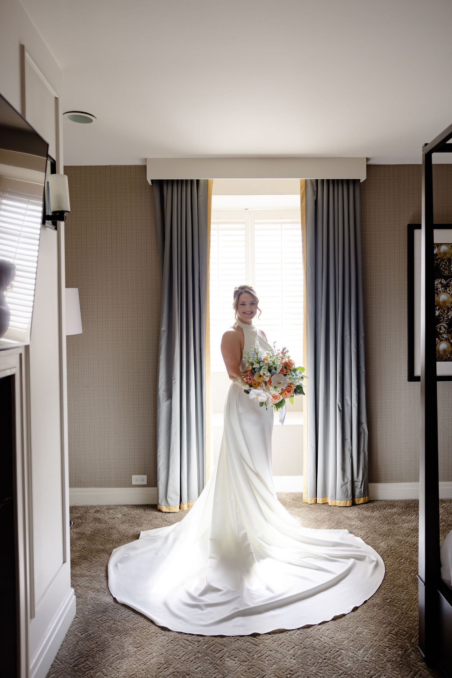 Elegant white wedding dress with long flowing train captured in sequence against neutral walls and blue curtains.