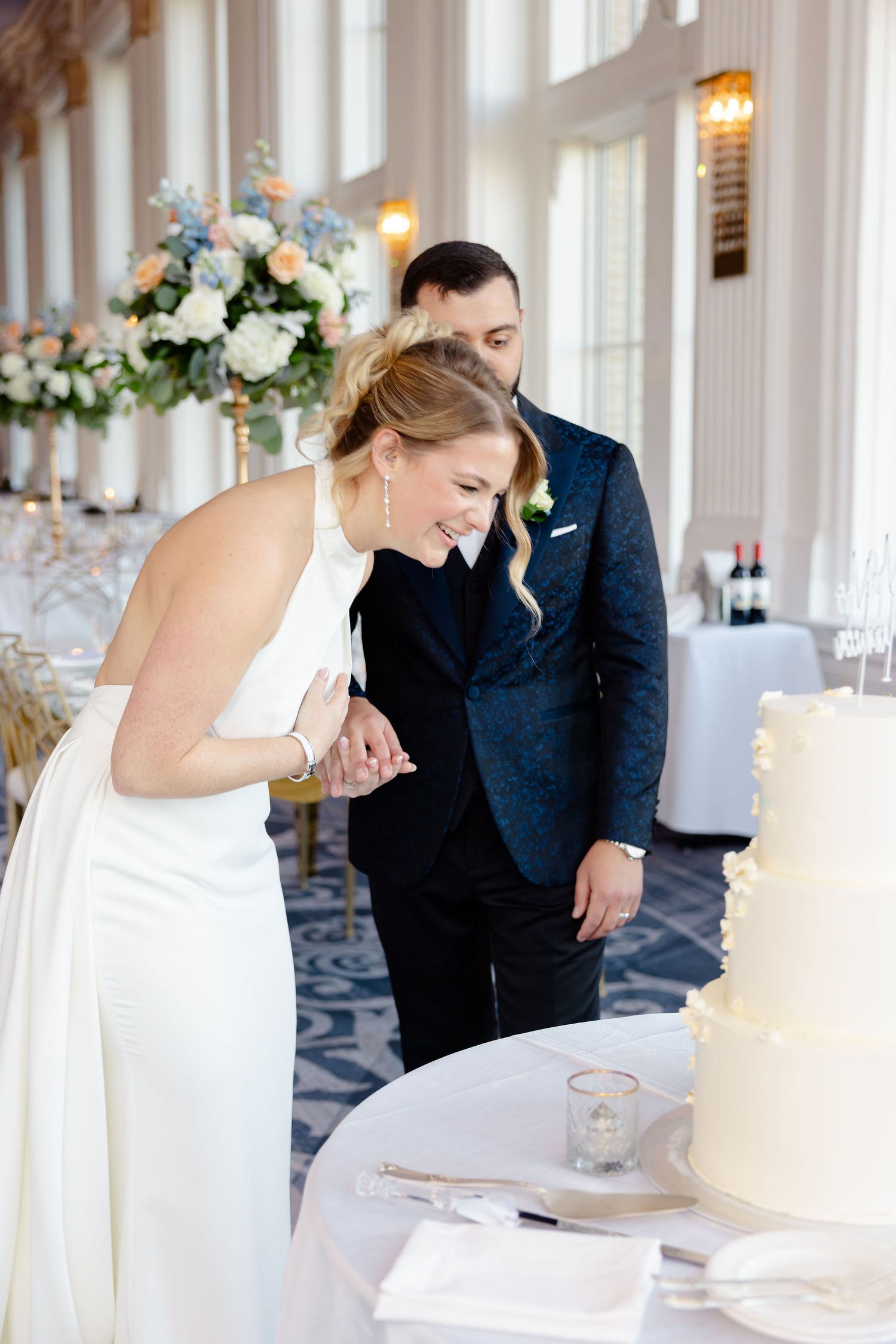 A joyful moment shared between a couple at their wedding cake table.