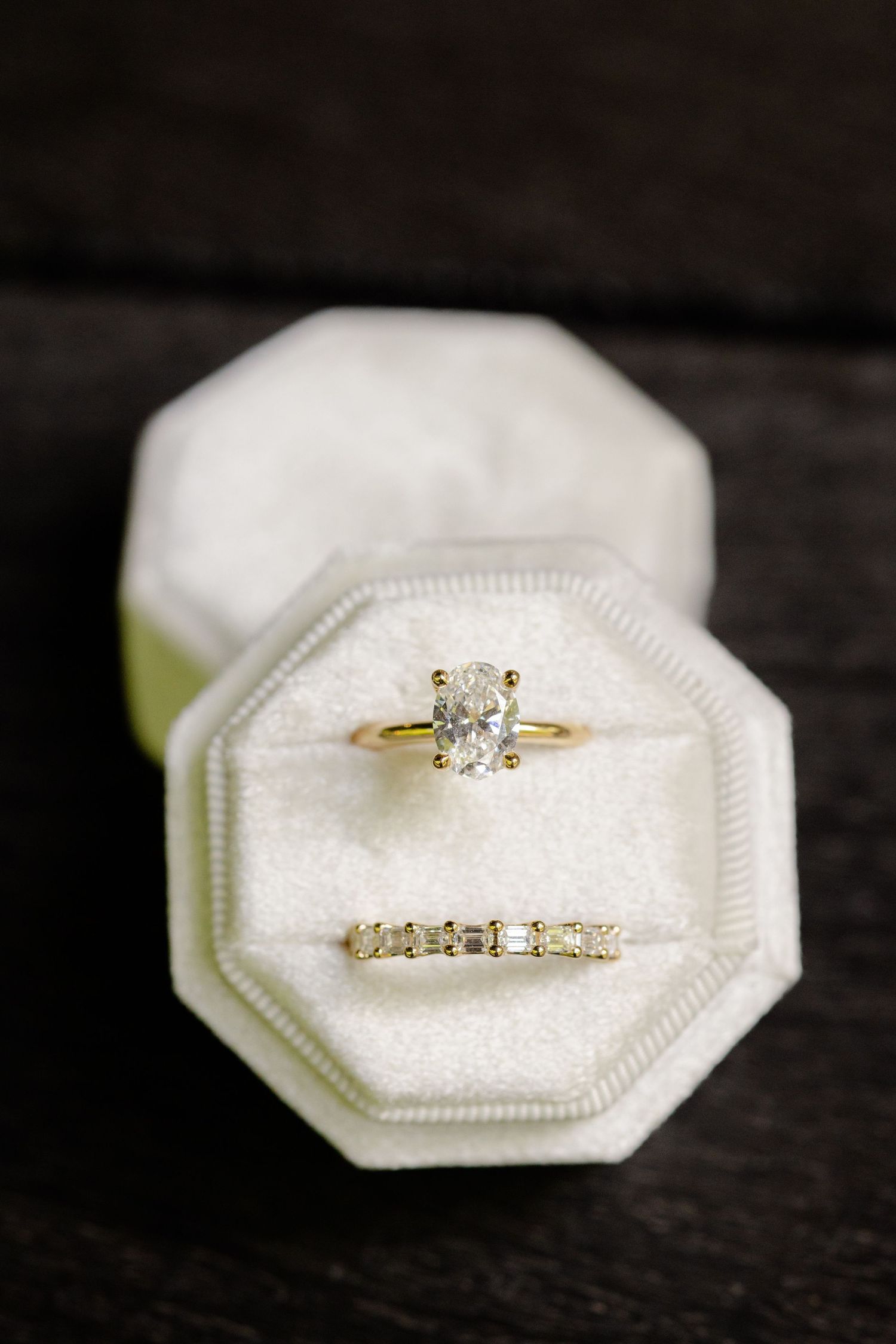 Diamond engagement ring and wedding band displayed in white octagonal velvet ring box.