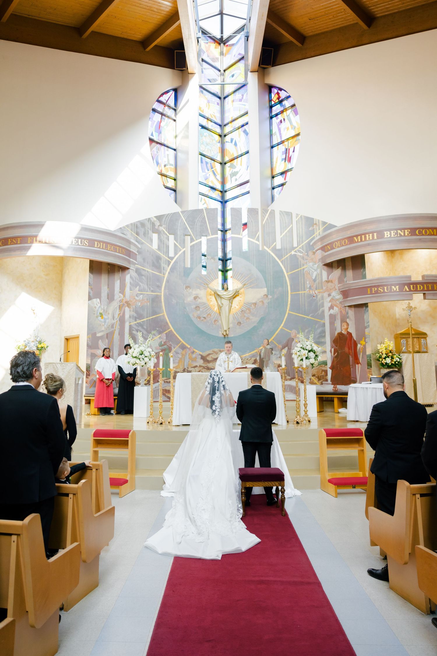 Modern church interior with stunning stained glass and architectural details during a wedding ceremony.