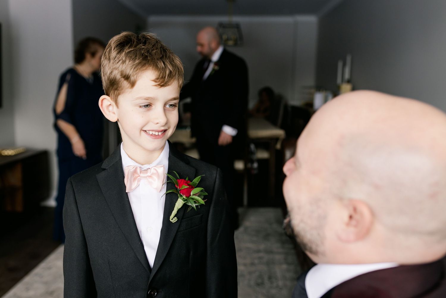 A candid moment captures pure joy during wedding preparations with a young attendee in formal wear.