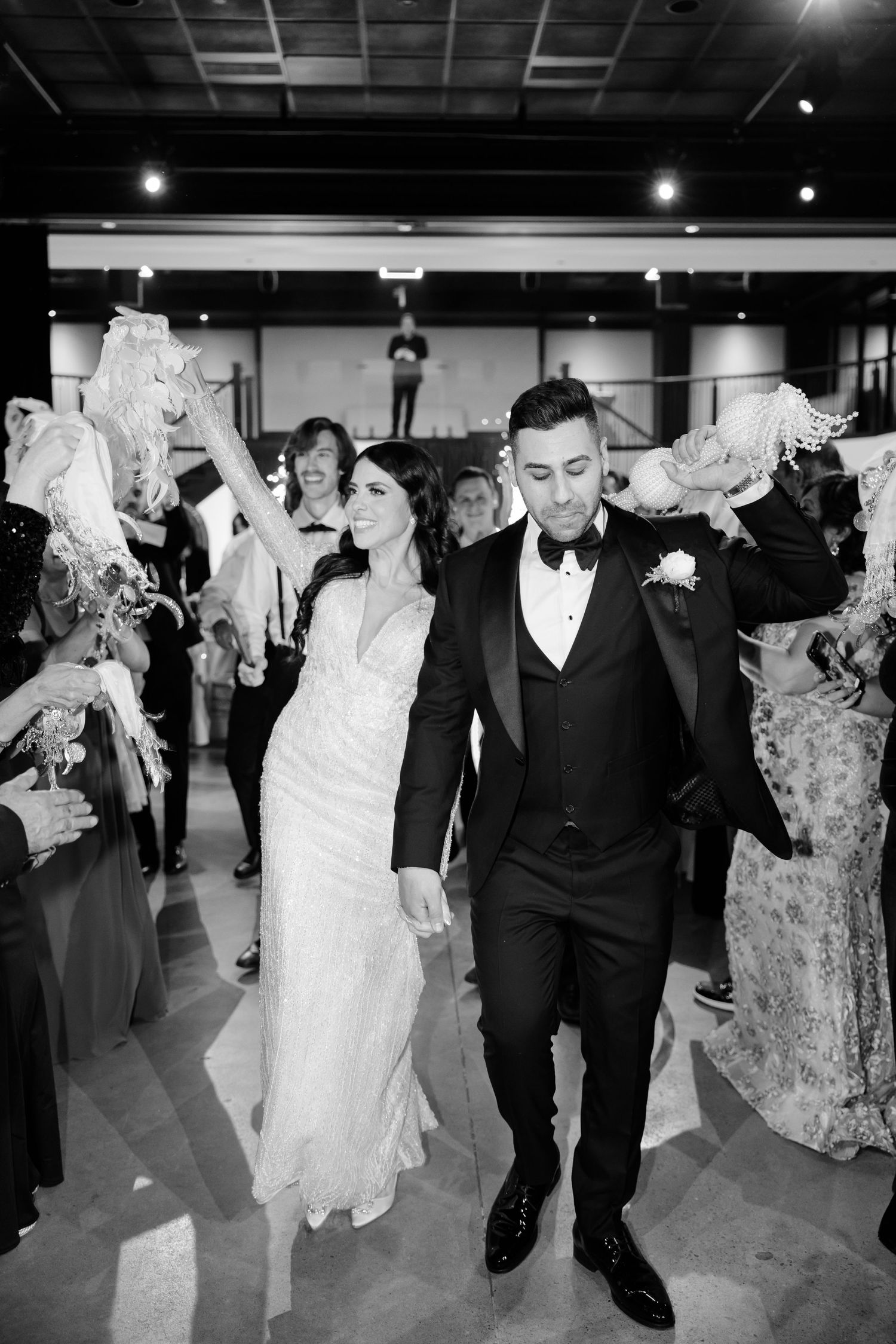 Black and white capture of a wedding celebration with guests forming an exit path.