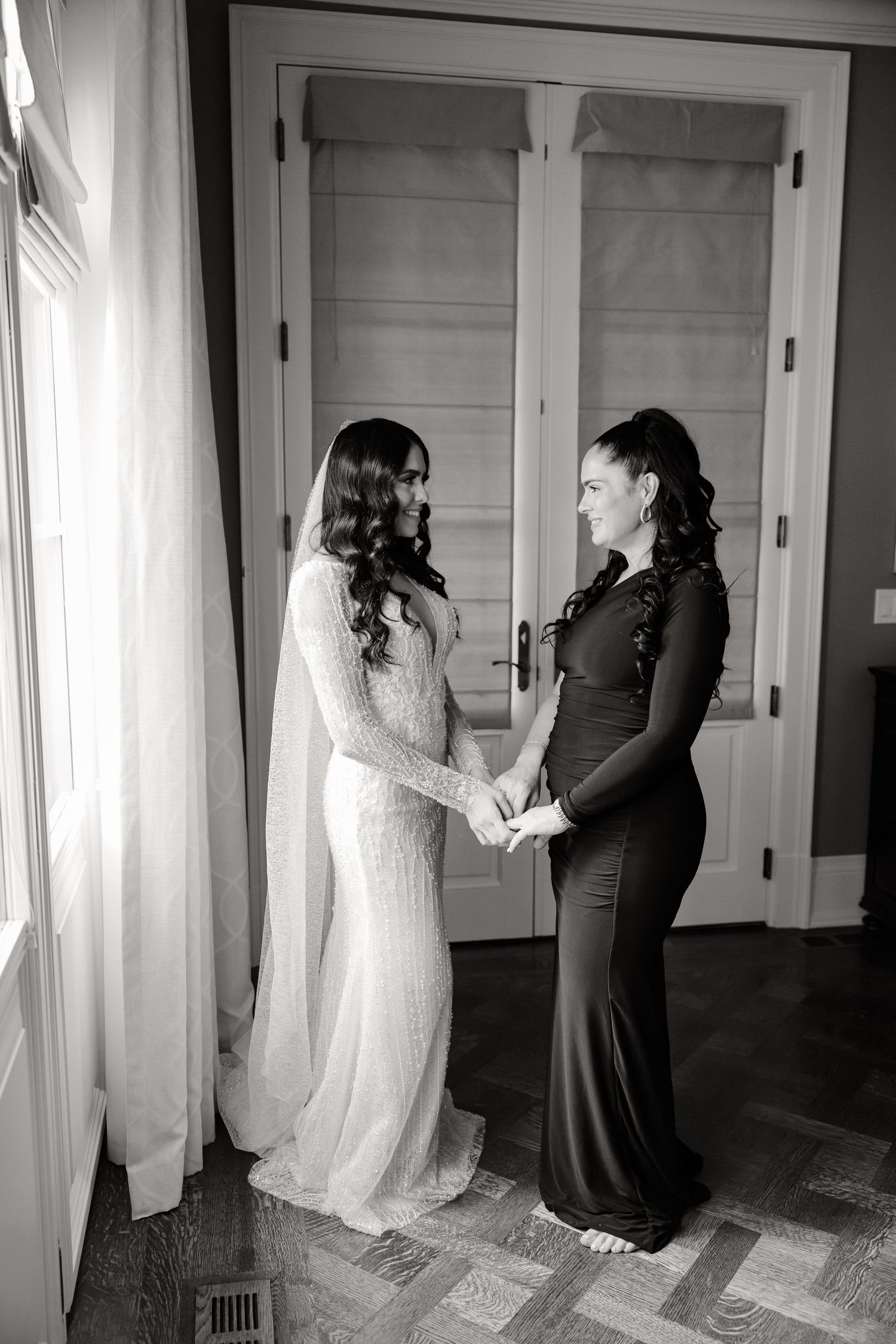 Black and white moment captured between two people in contrasting formal dresses.