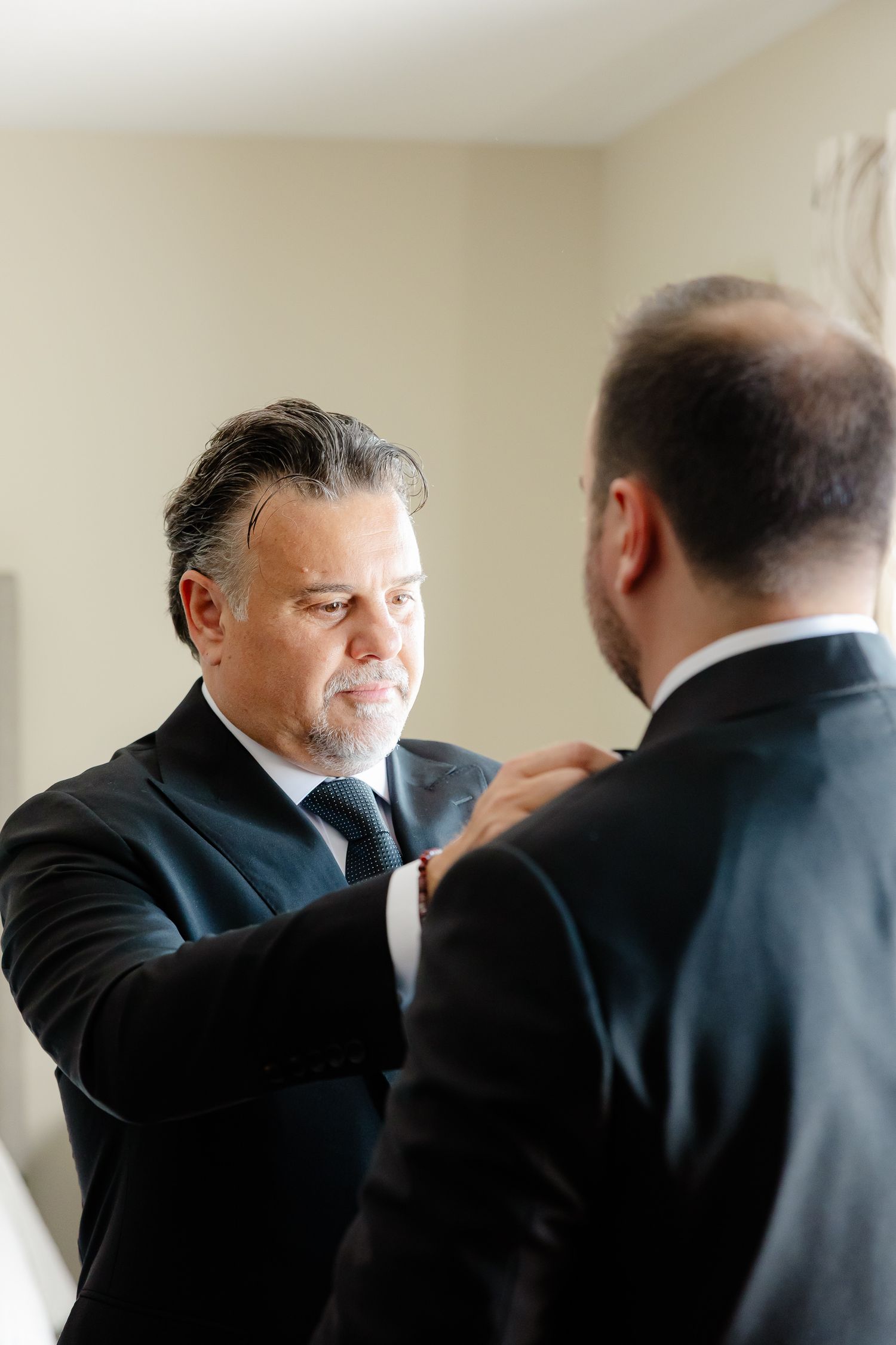 Two men in business suits share a moment of laughter while having a professional conversation.