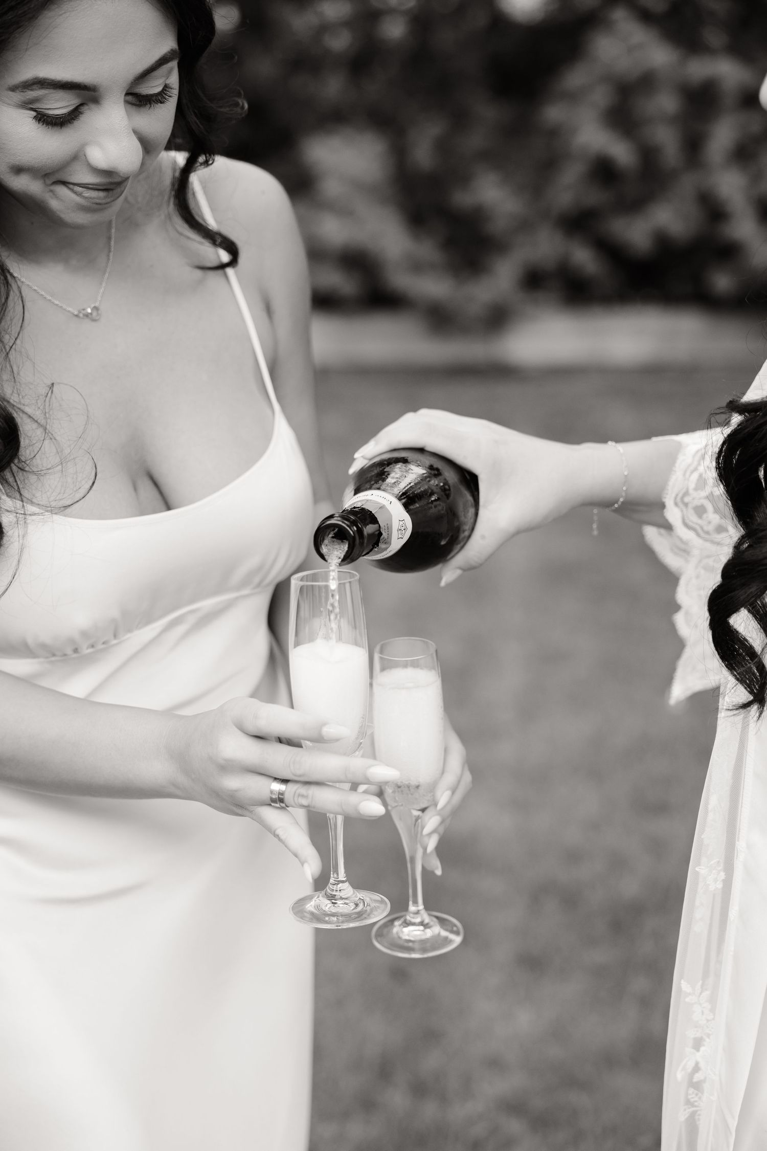 Four sequential images showing someone in a white dress carefully pouring a drink into a glass outdoors.