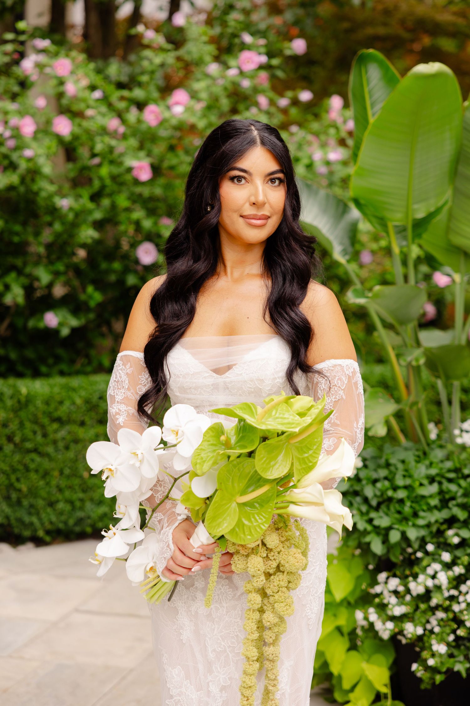 A beautiful bridal photo series featuring an off-shoulder lace gown and tropical green and white bouquet.