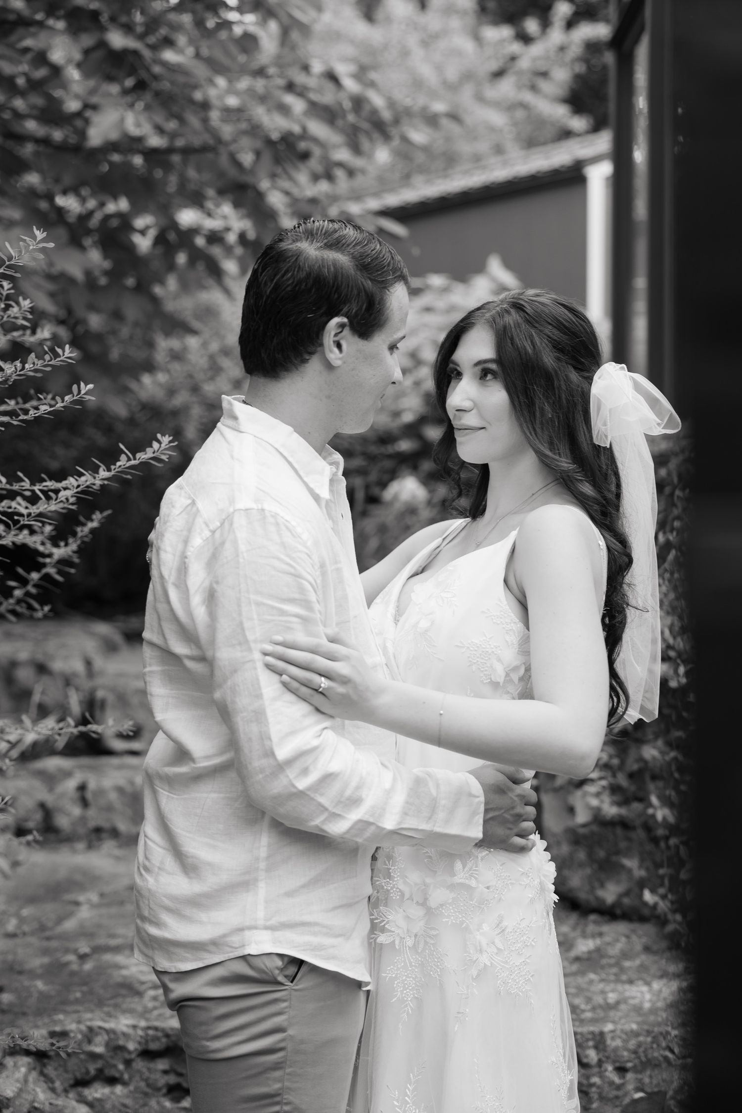 Black and white wedding portrait capturing a tender moment between newlyweds.