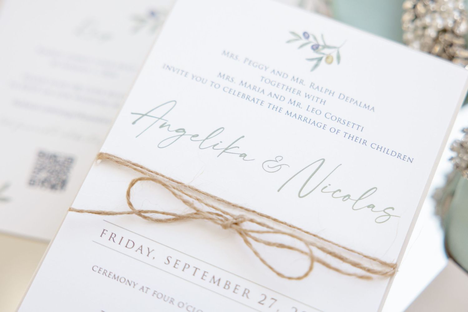 Wedding invitation featuring delicate calligraphy names tied with rustic twine.